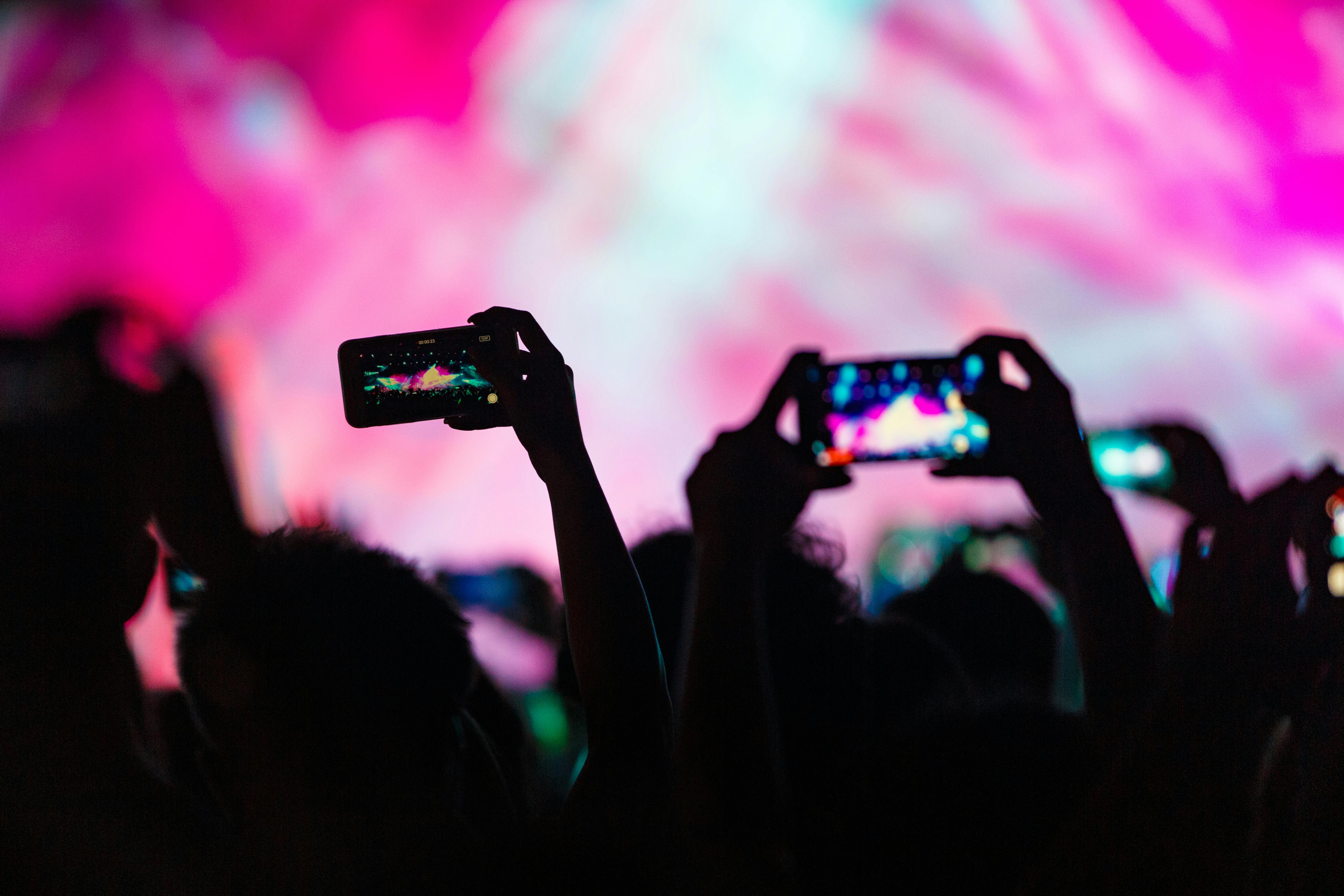 Gente levantando sus teléfonos para grabar y hacer fotos | Fuente: Pexels
