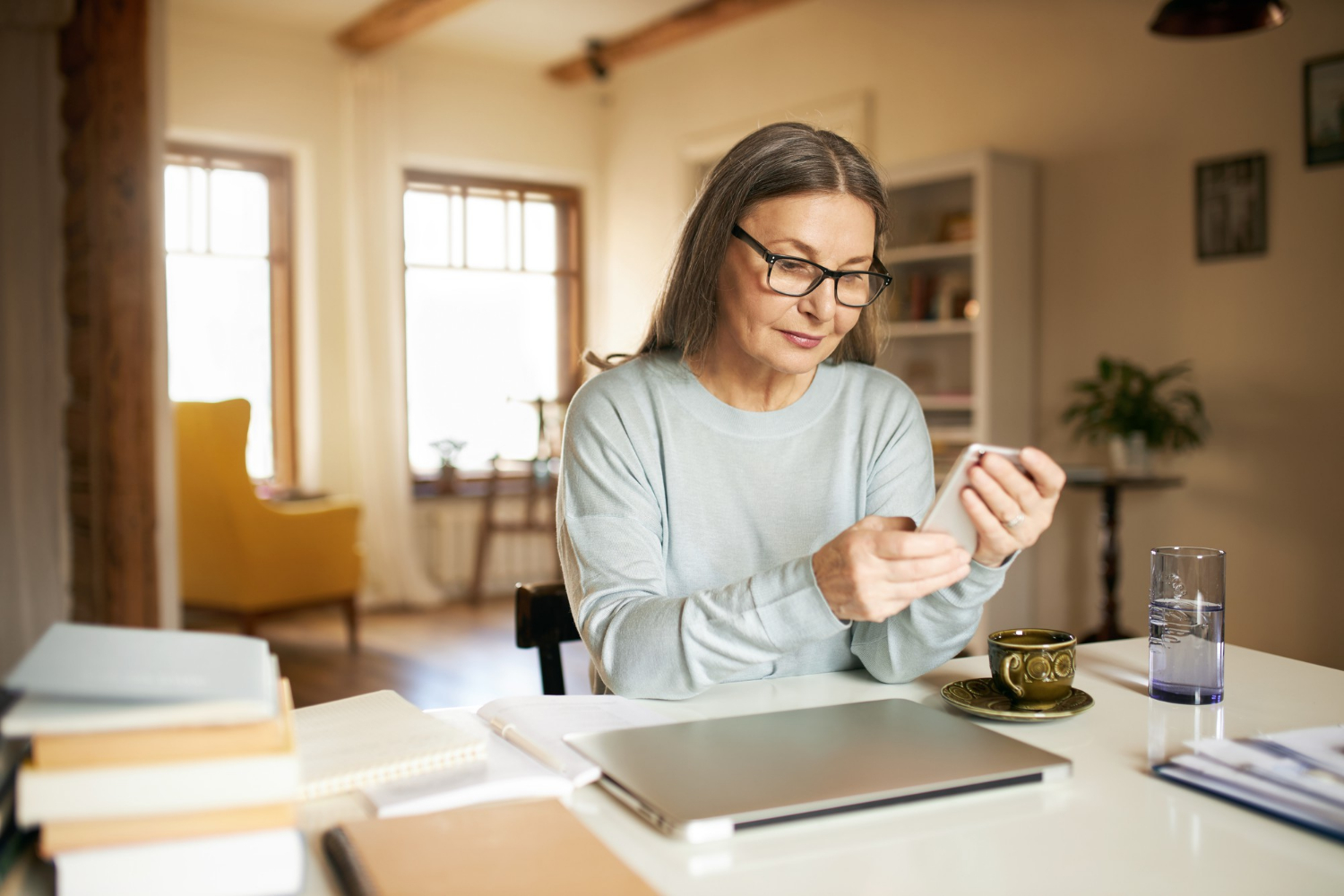 Una anciana ansiosa sujetando su teléfono | Fuente: Freepik