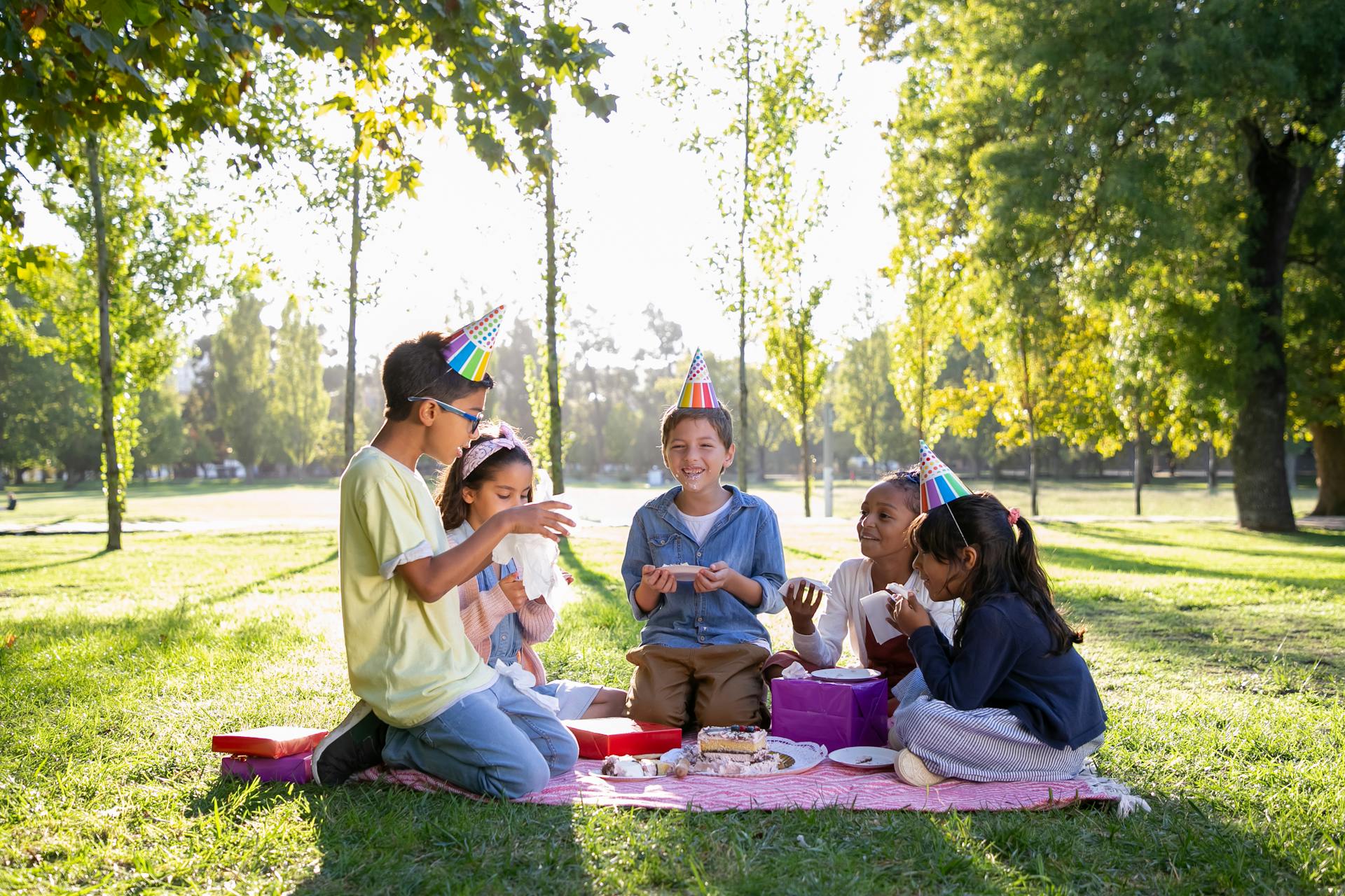 Niños sentados al aire libre con sombreros de fiesta | Fuente: Pexels