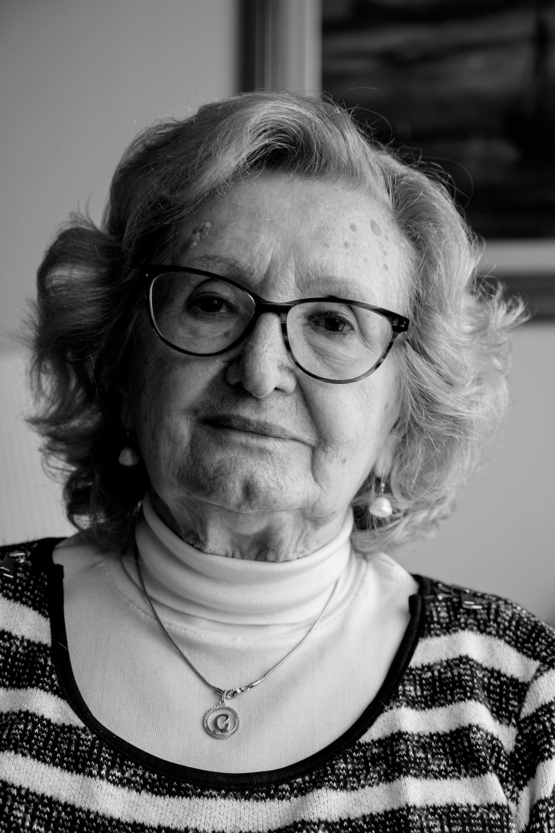 Retrato en blanco y negro de una anciana con gafas y suéter de rayas | Fuente: Pexels
