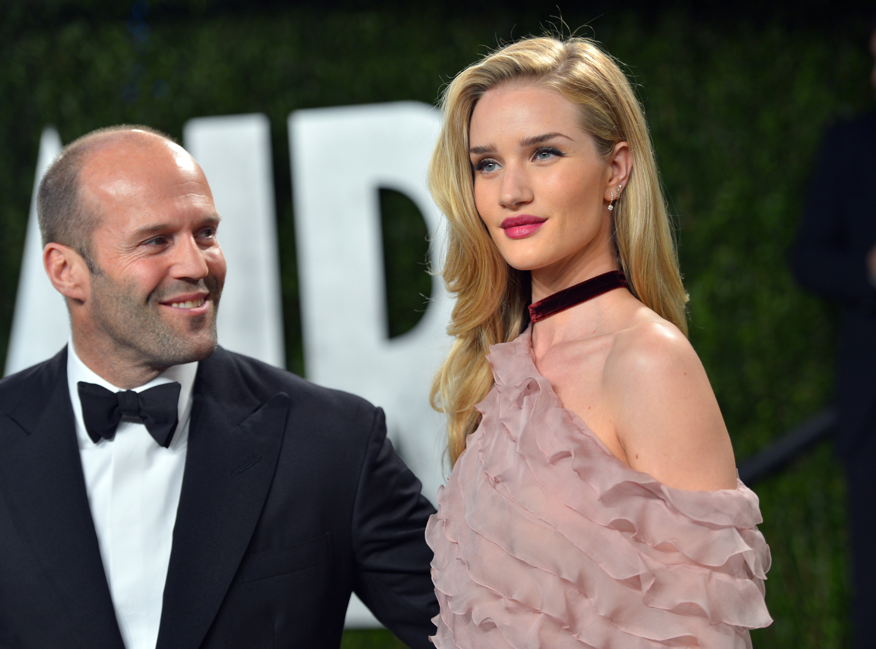 Rosie Huntington-Whiteley y Jason Statham comparten un momento en la alfombra roja: la clásica corbata negra se combina con un glamour suave y romántico, con un toque del encanto del viejo Hollywood. | Fuente: Getty Images