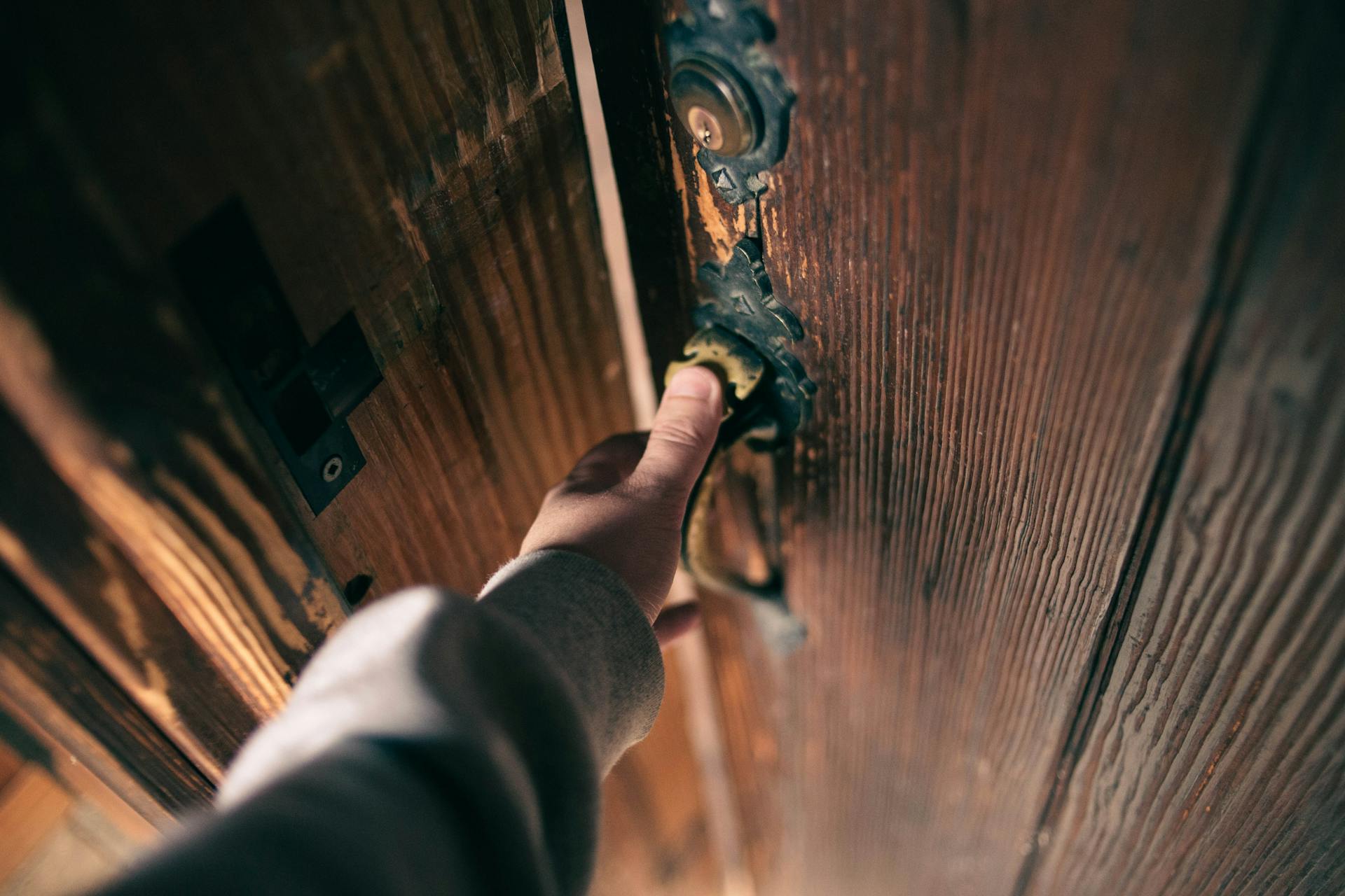 Un hombre sujetando la manilla de una puerta | Fuente: Pexels