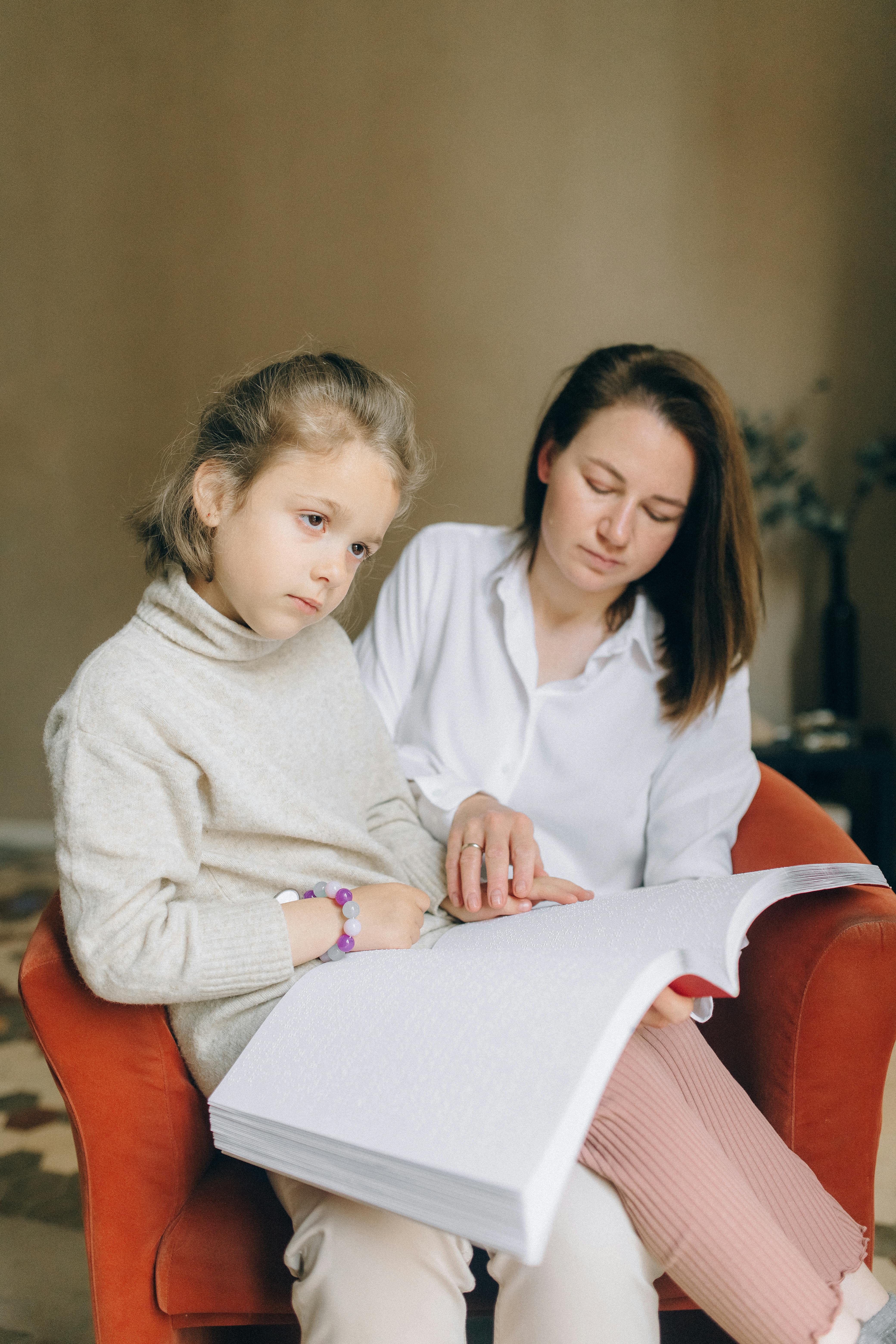 Una mujer ayudando a su hija a leer | Fuente: Pexels
