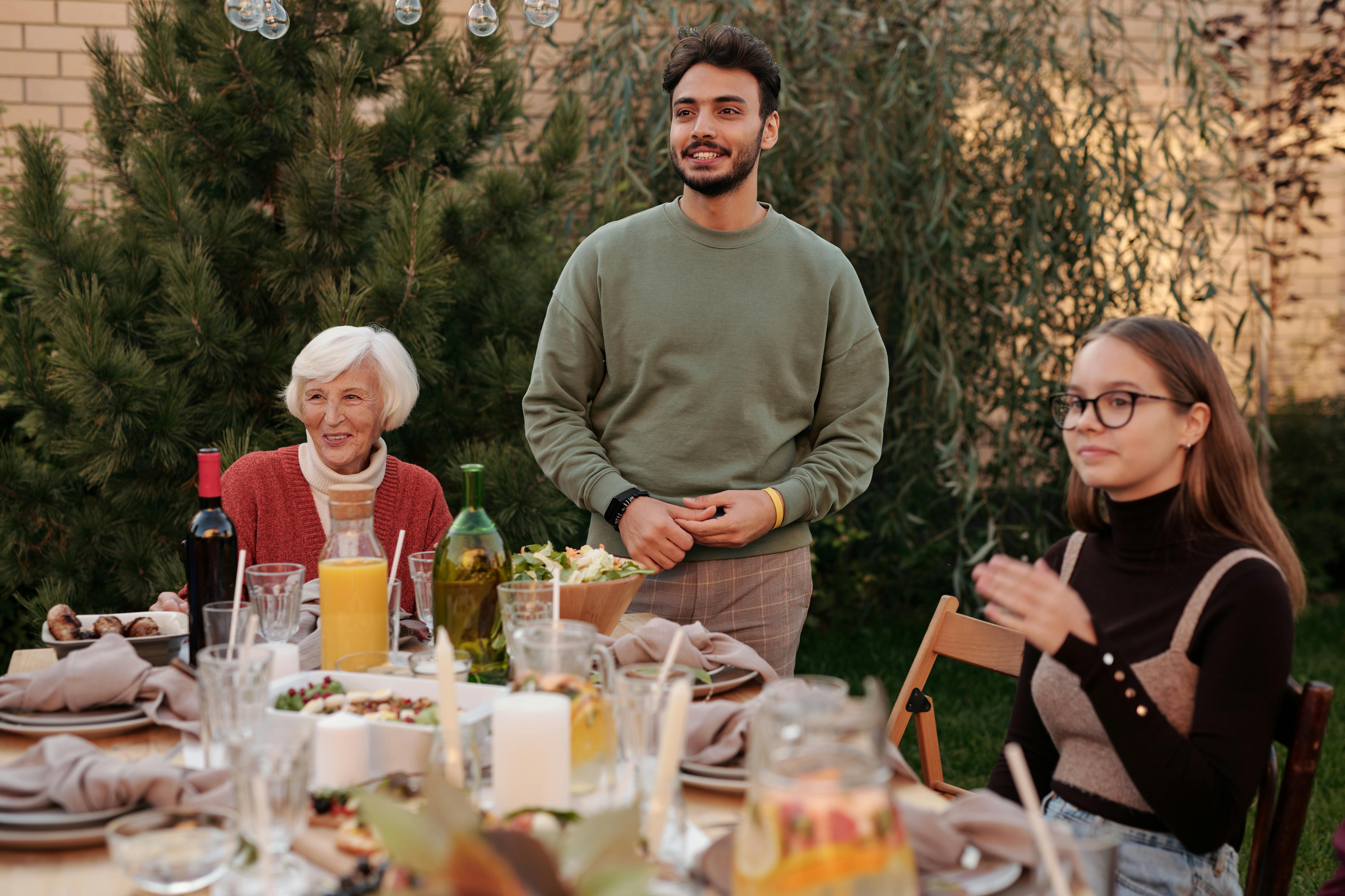 Una familia sentada a la mesa | Fuente: Pexels