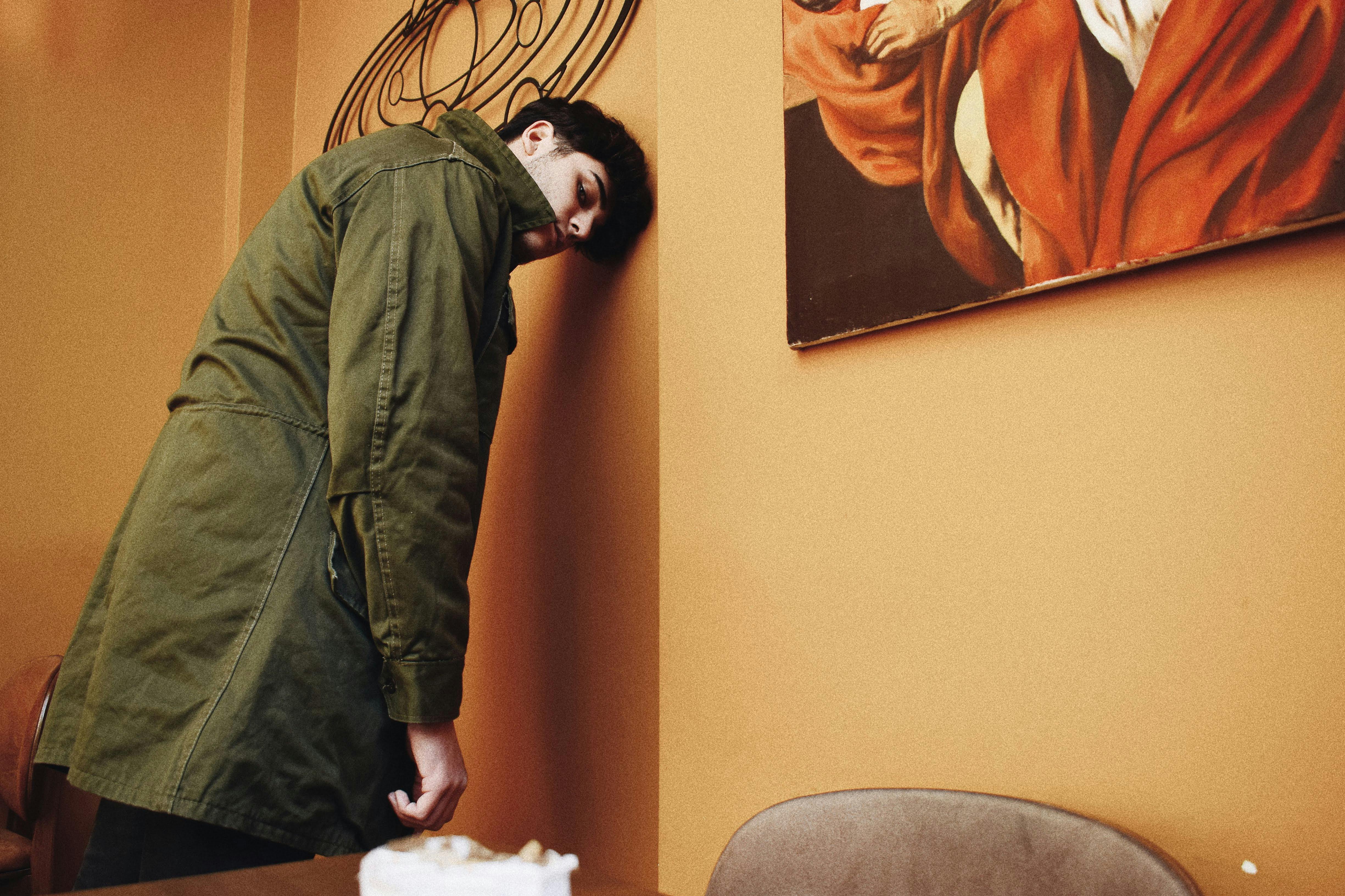 Un hombre exhausto apoyado en una pared | Fuente: Pexels