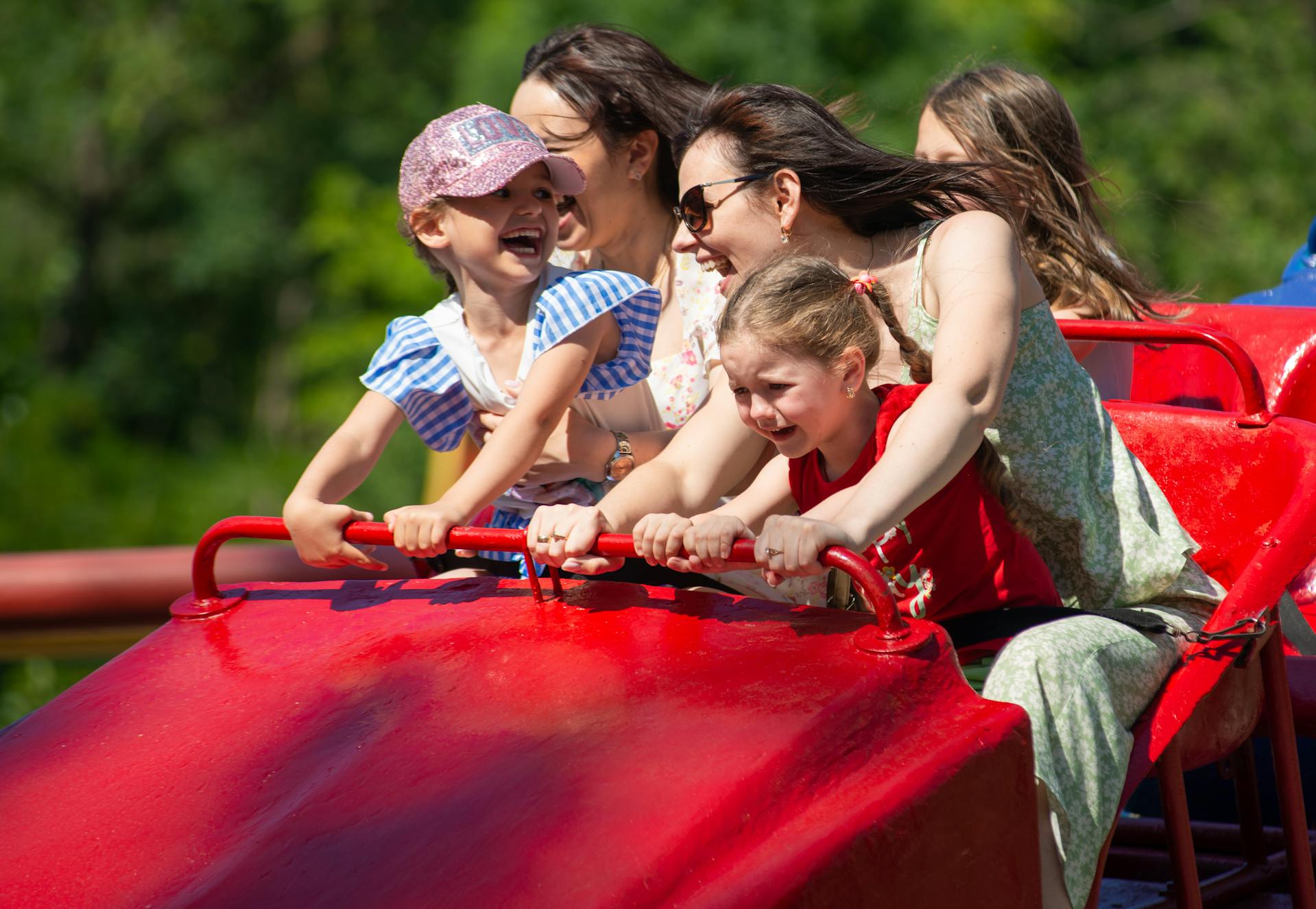 Mujeres y niños subidos a una montaña rusa en un parque de atracciones | Fuente: Pexels