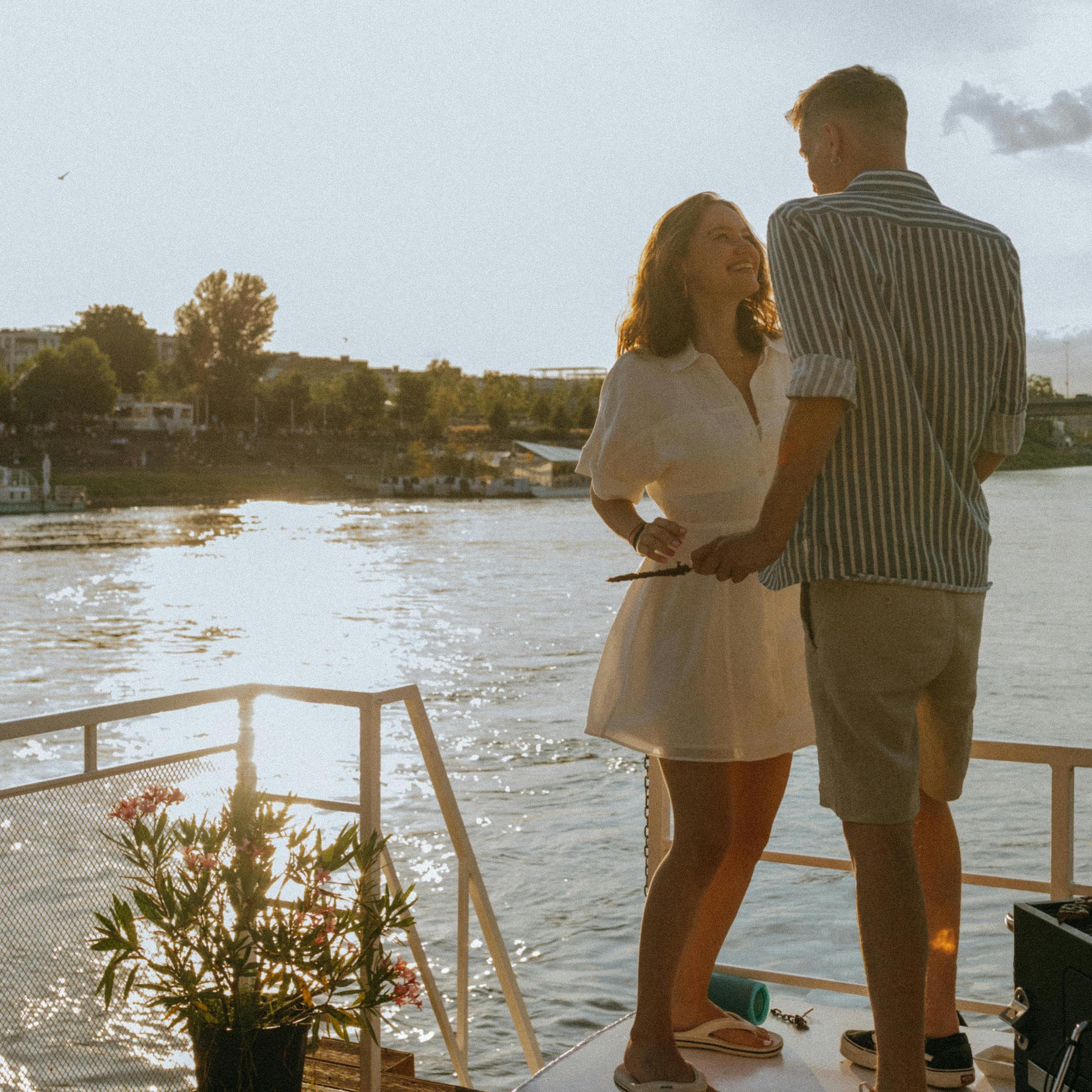 Una mujer sonriendo, hablando con un hombre en la cubierta de un barco | Fuente: Pexels