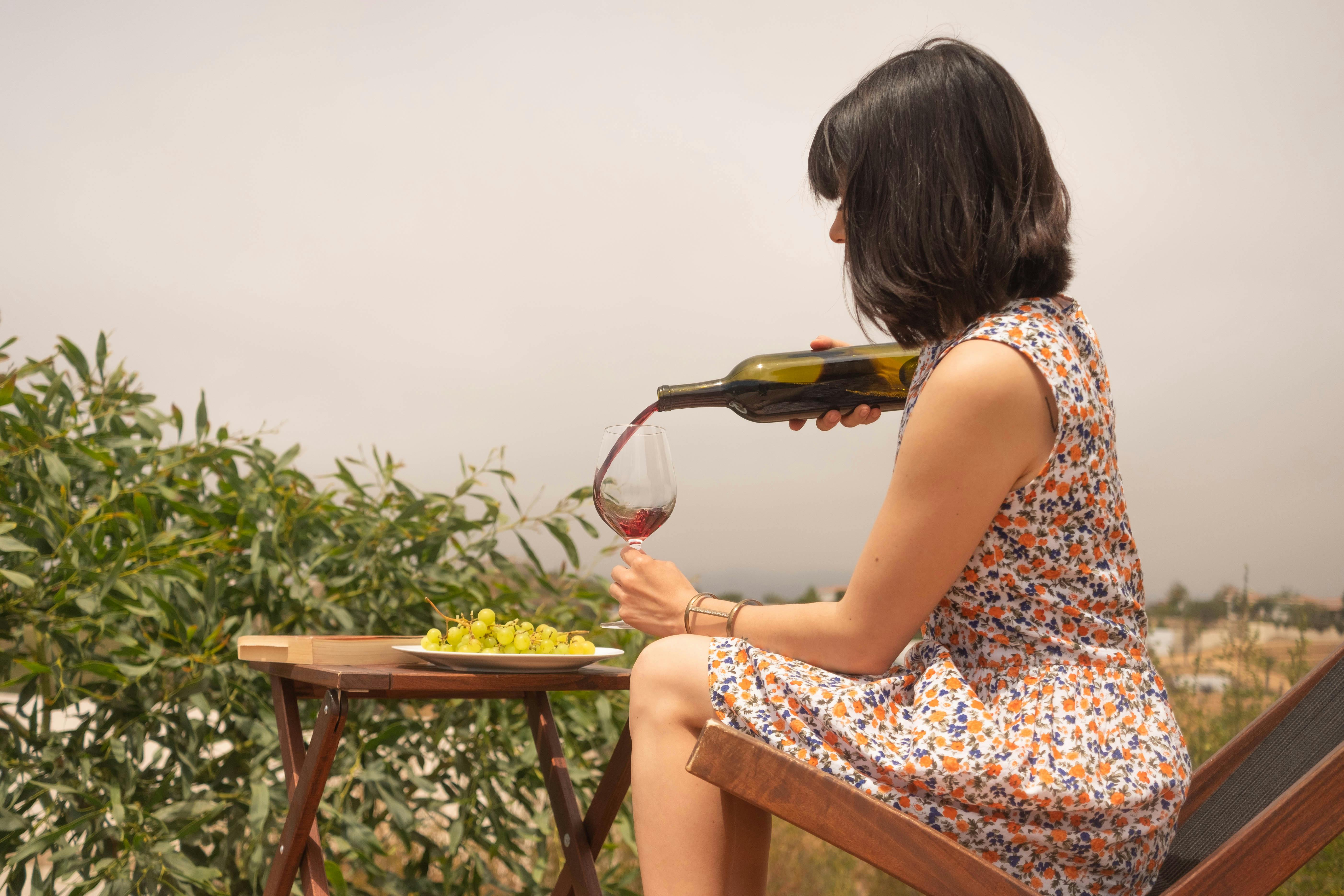 Mujer sirviendo vino en un vaso | Fuente: Pexels