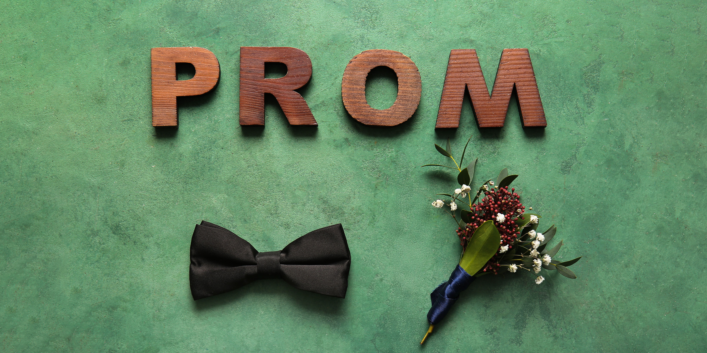 Letras que deletrean "Prom", una pajarita y un ramillete de ojal | Fuente: Shutterstock