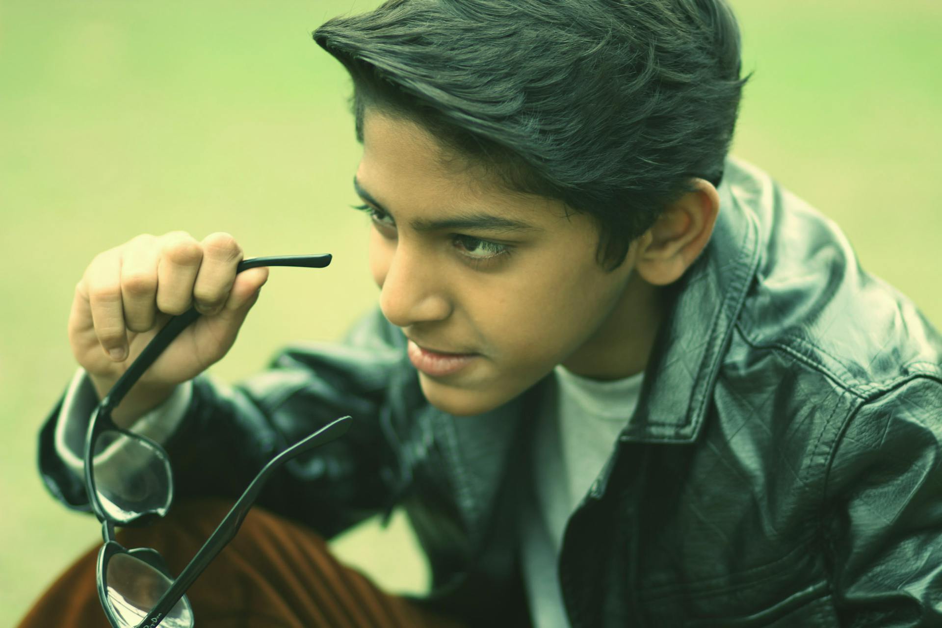 Un adolescente quitándose las gafas | Fuente: Pexels