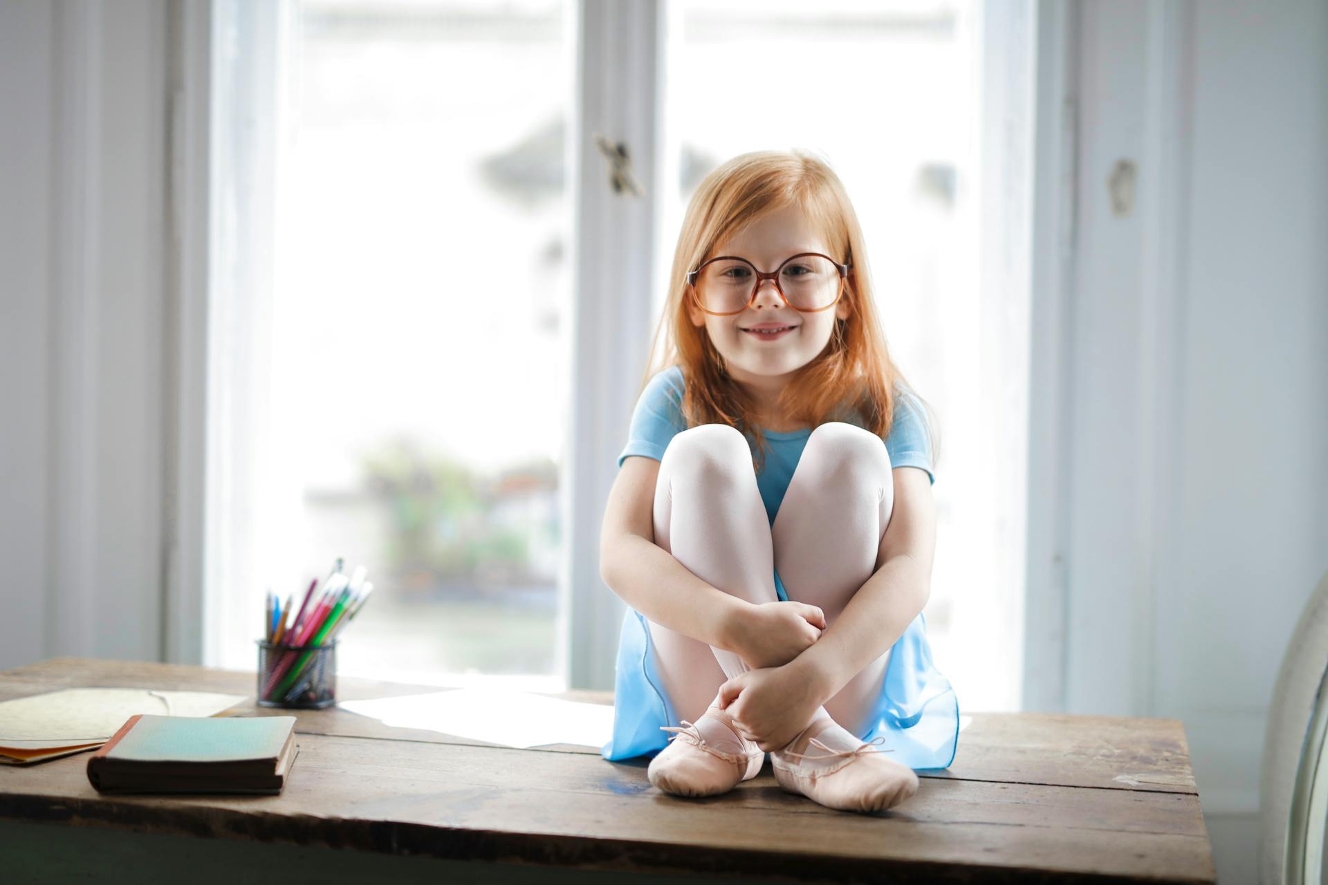 Una niña sentada en una mesa | Fuente: Pexels