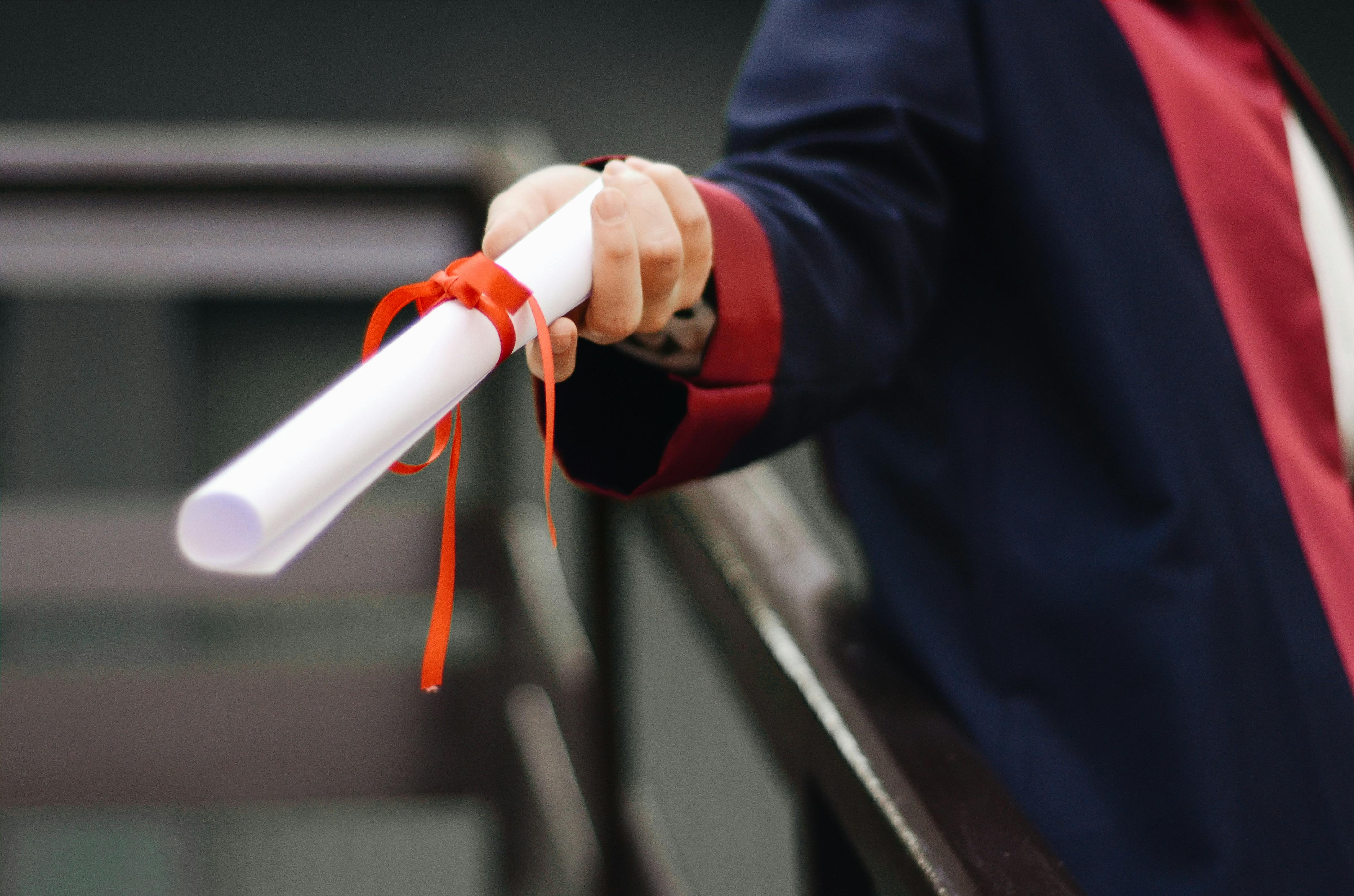 Una graduada con su diploma | Fuente: Pexels