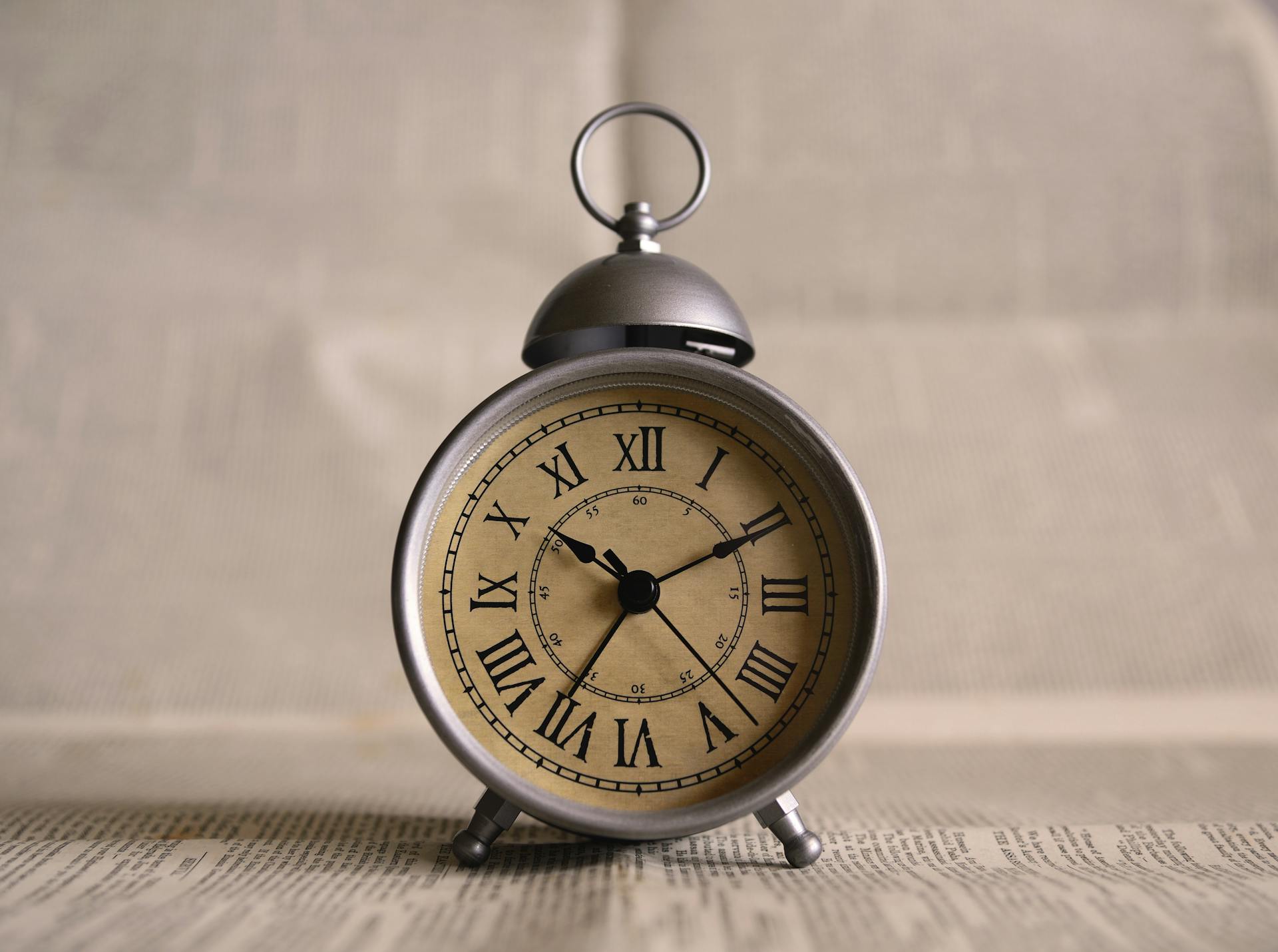 Un reloj antiguo sobre un trozo de periódico | Fuente: Pexels