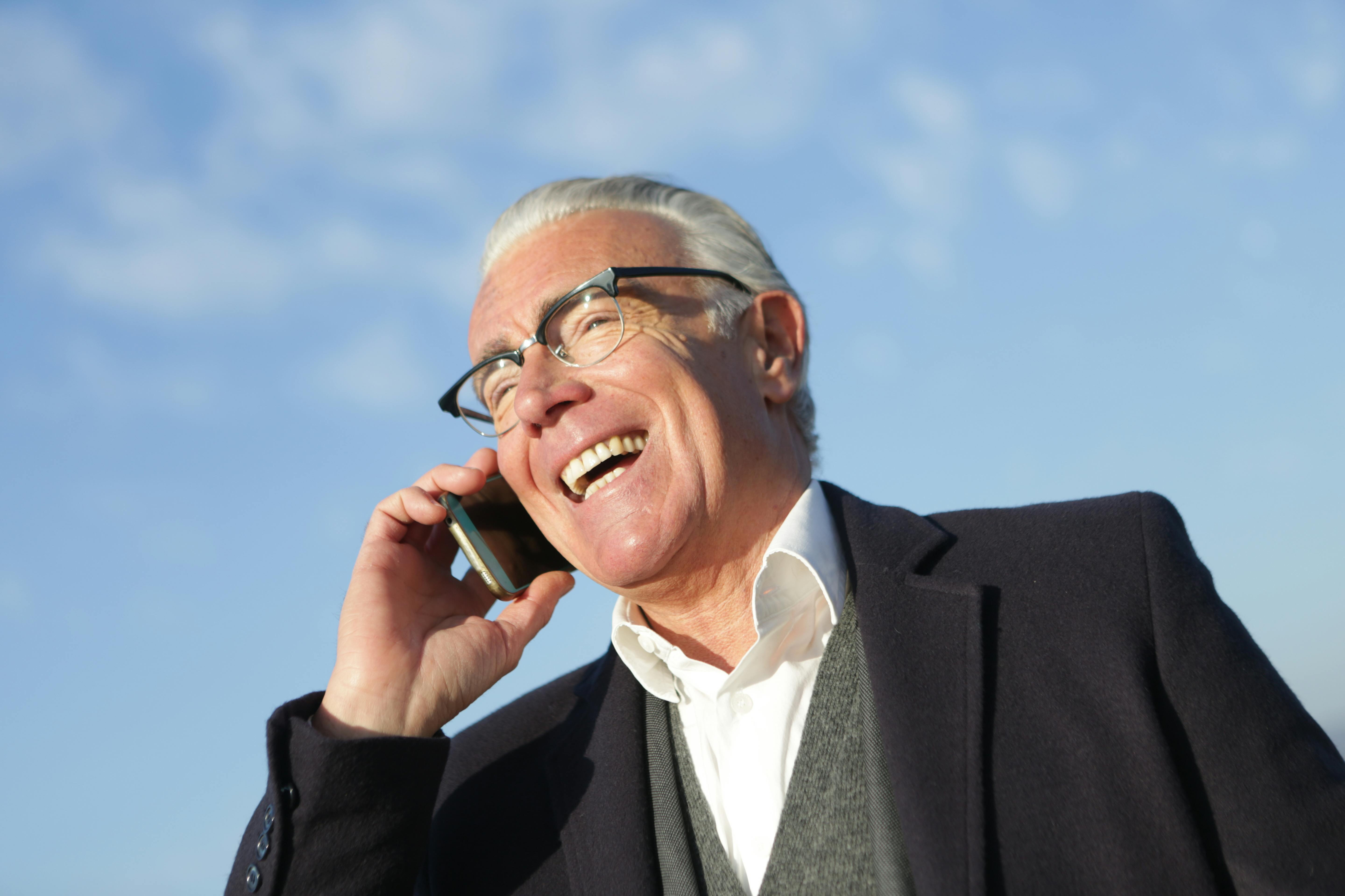 Un hombre mayor feliz al teléfono | Fuente: Pexels