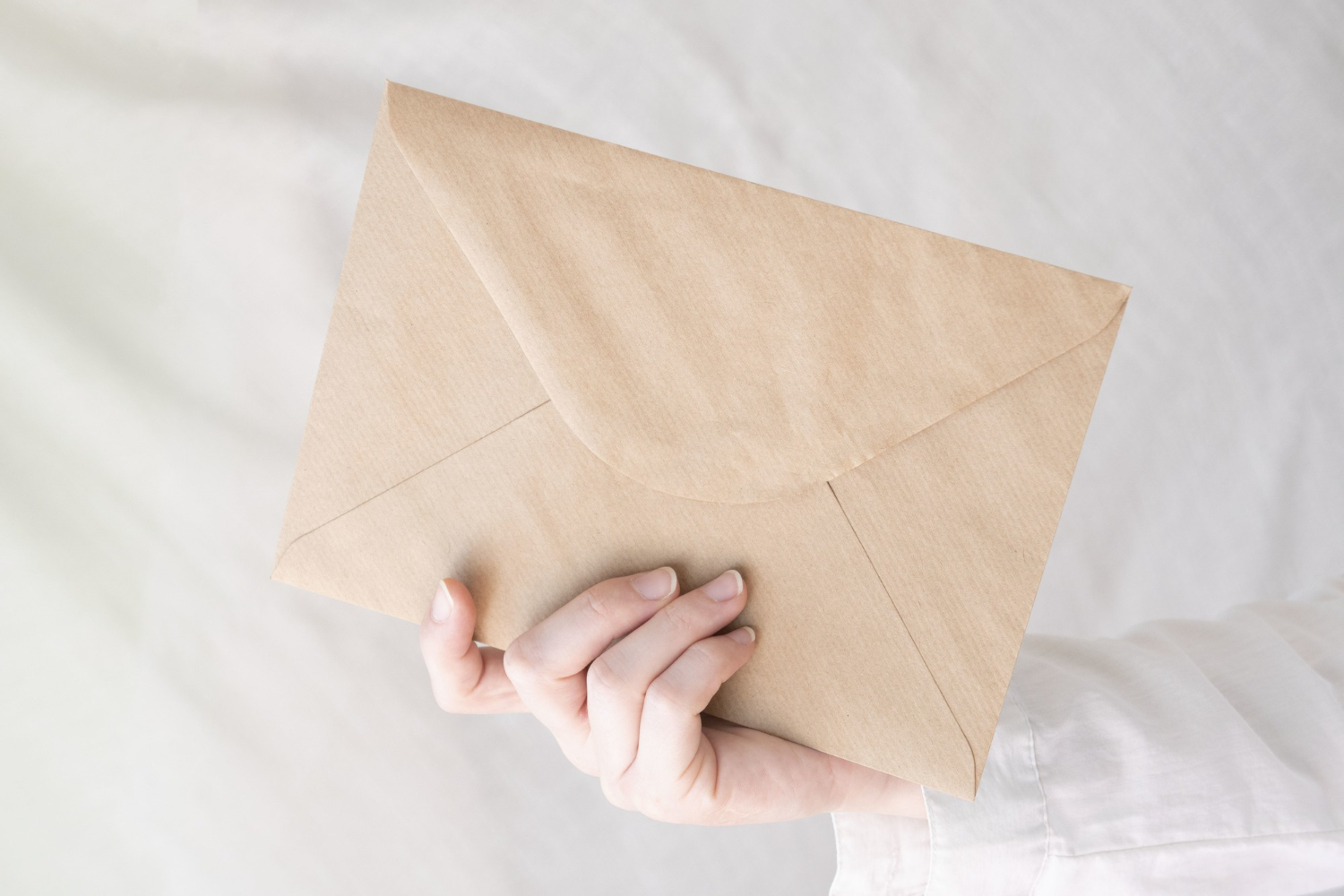 Uma pessoa segurando um envelope | Fonte: Freepik