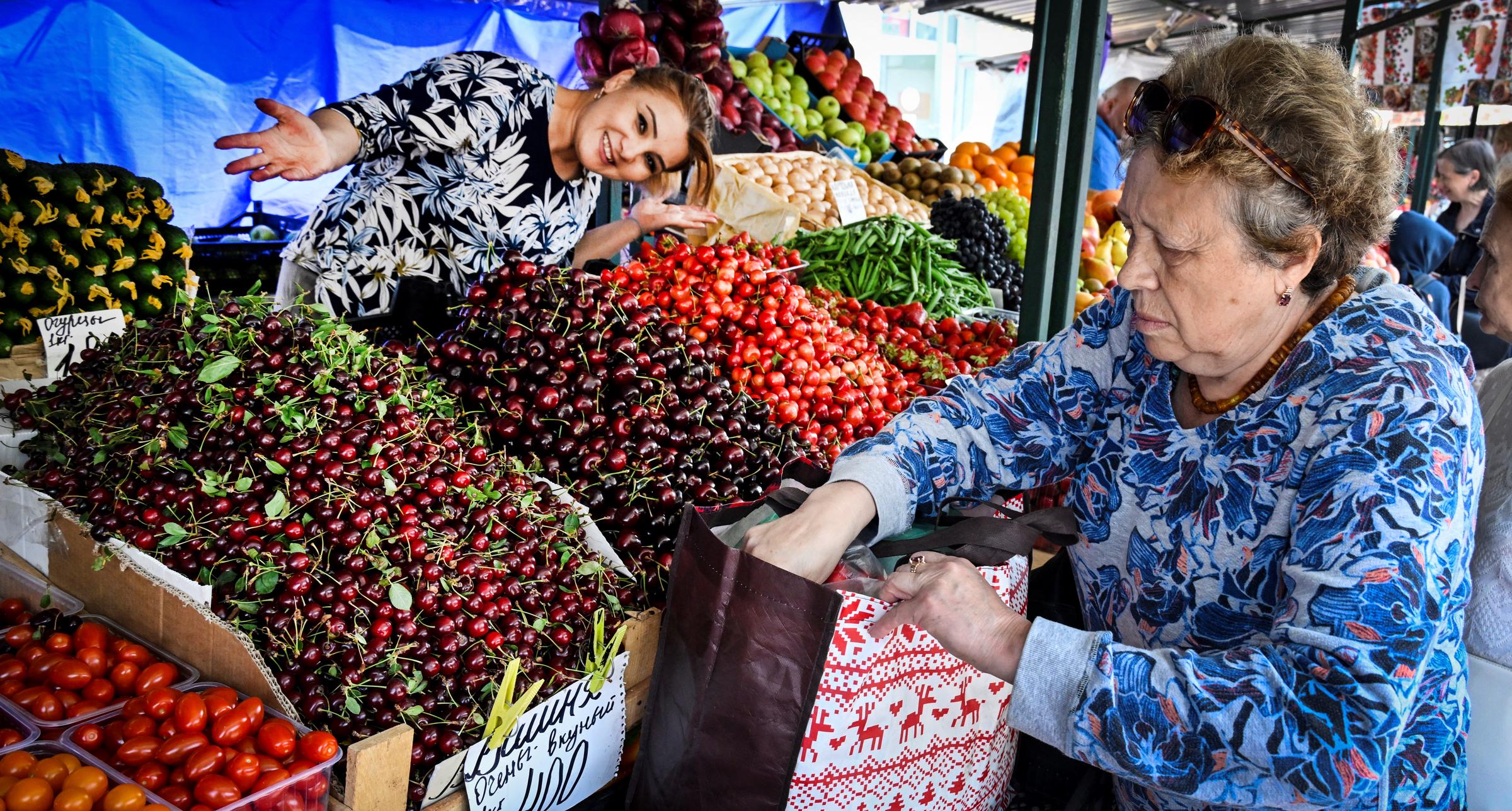 Un vendedor ofrece cerezas y verduras en un mercado | Fuente: Getty Images