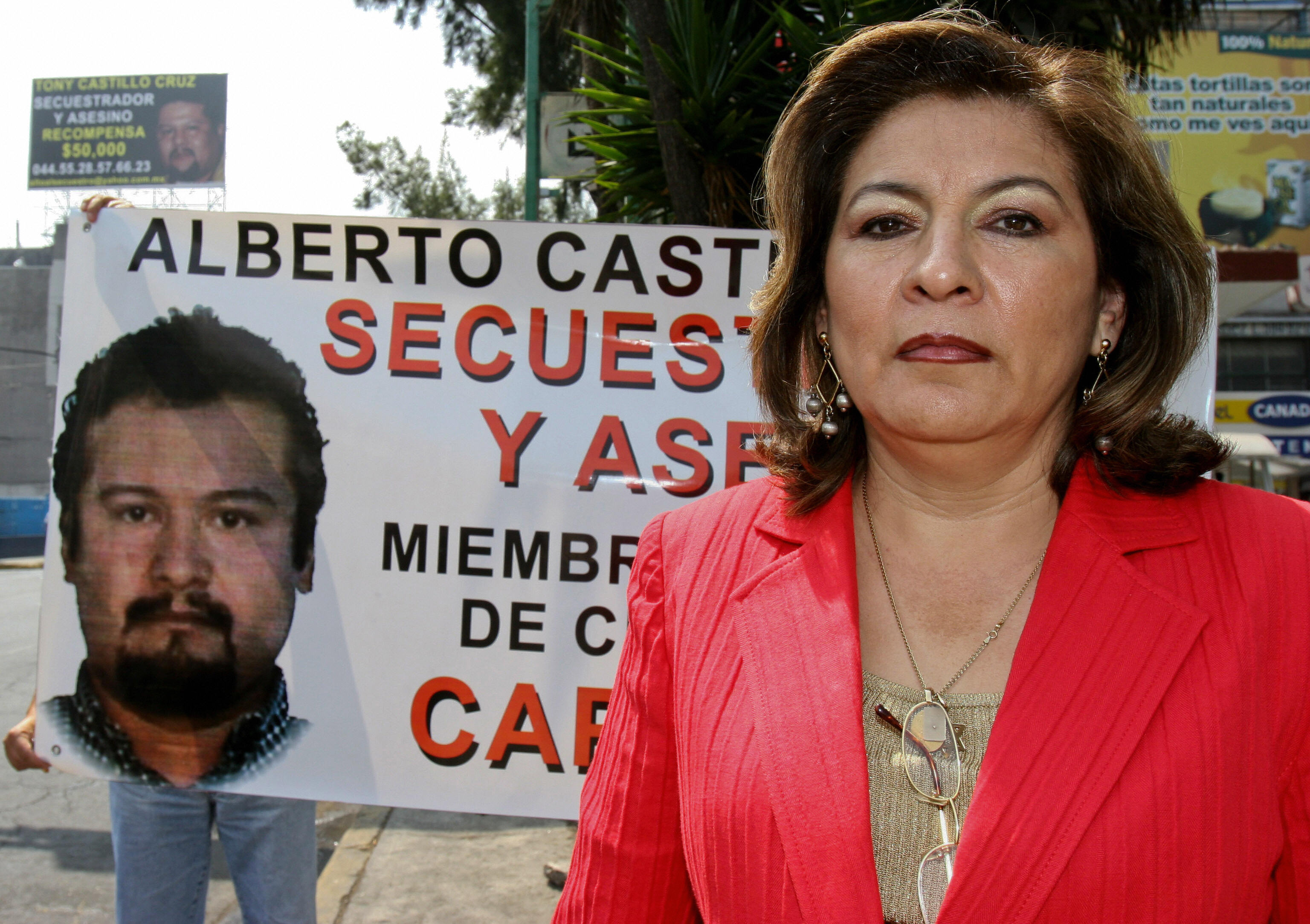 Fotografía tomada el 15 de marzo de 2006 de la mexicana Isabel Miranda Wallace frente a una pancarta con el retrato de un presunto miembro de la banda de secuestradores que raptó a su hijo Hugo Alberto Wallace hace tres años. | Fuente: Getty Images