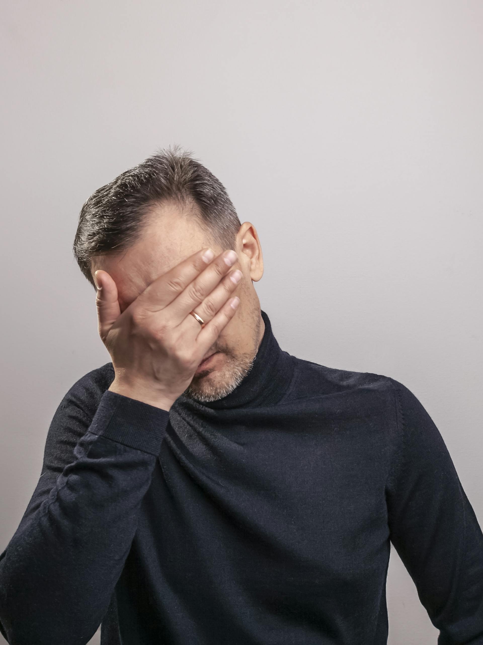 Un hombre cubriéndose la cara con la mano | Fuente: Pexels