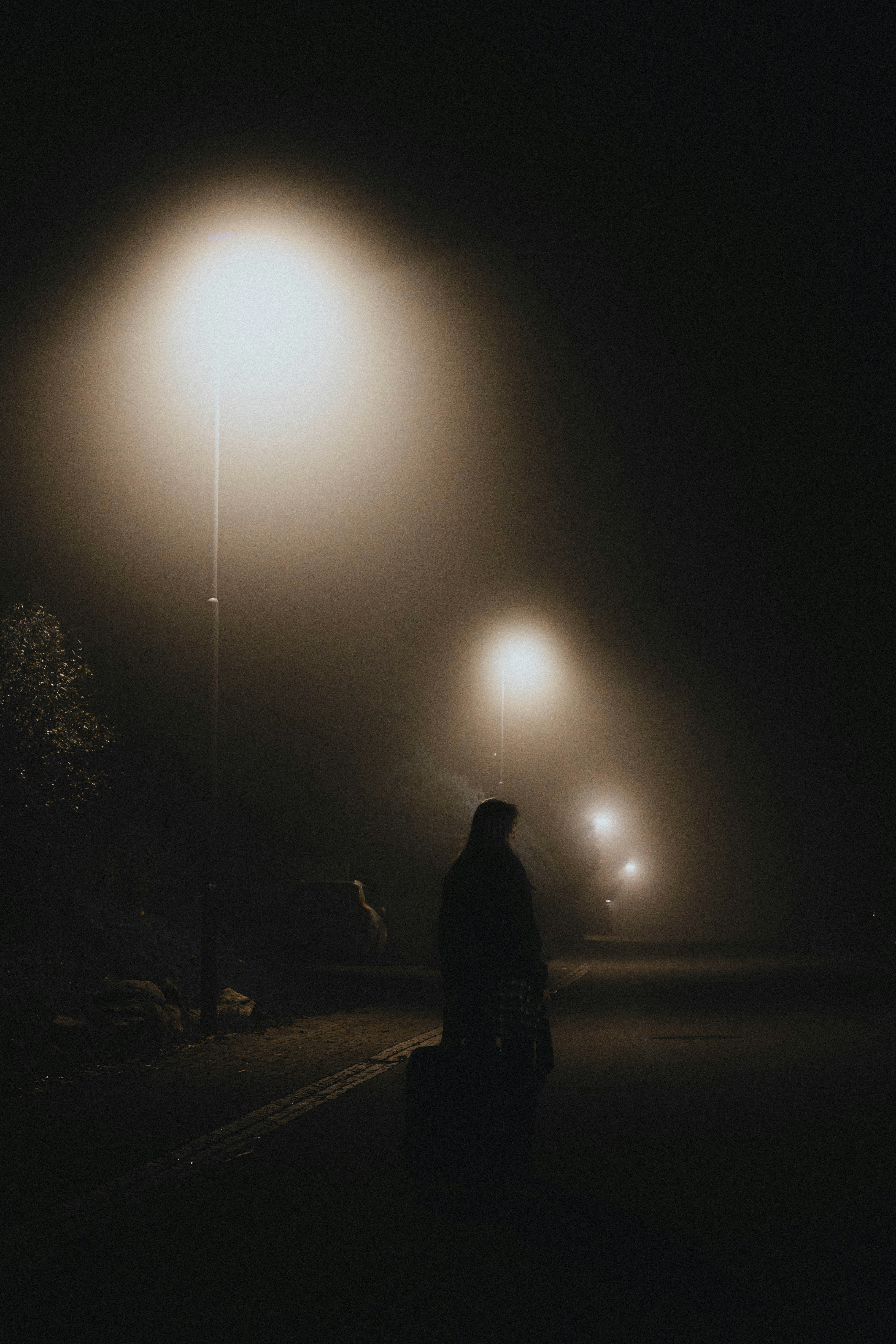 Una mujer de pie en una calle de noche | Fuente: Unsplash