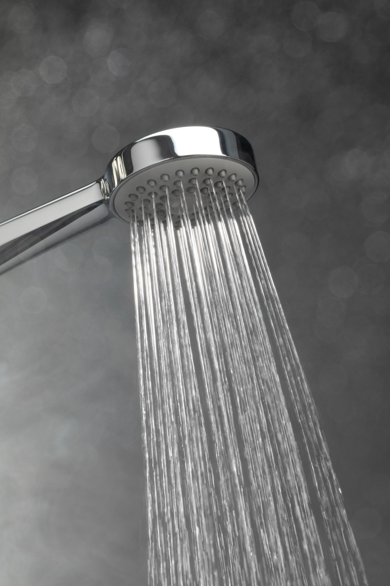 Agua fluyendo por una alcachofa de ducha | Fuente: Freepik