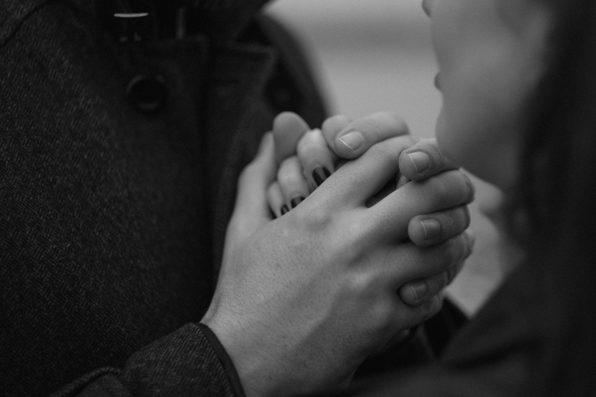 Foto en escala de grises de una pareja cogida de la mano | Fuente: Pexels