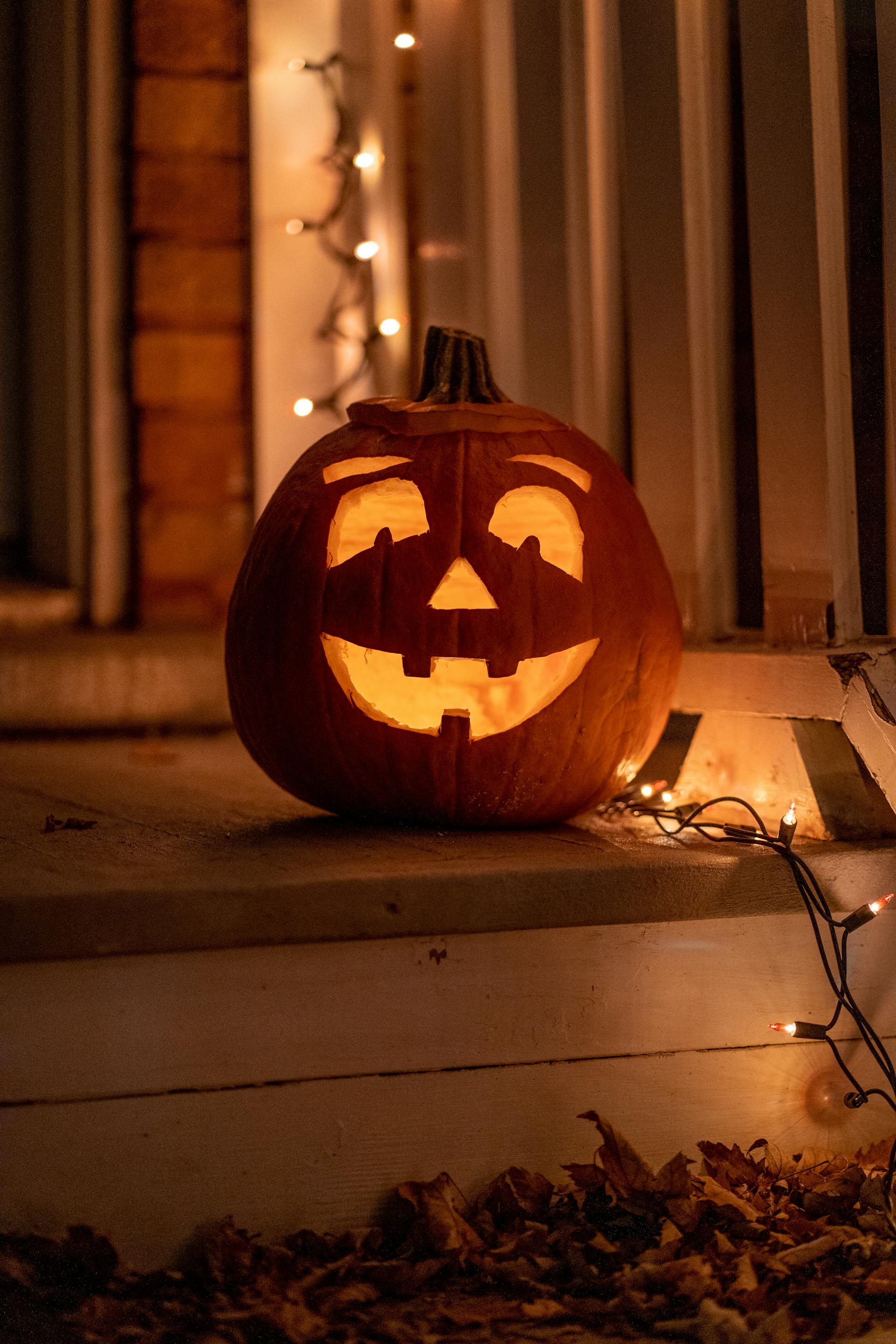 Una calabaza tallada para Halloween junto a luces parpadeantes | Fuente: Pexels
