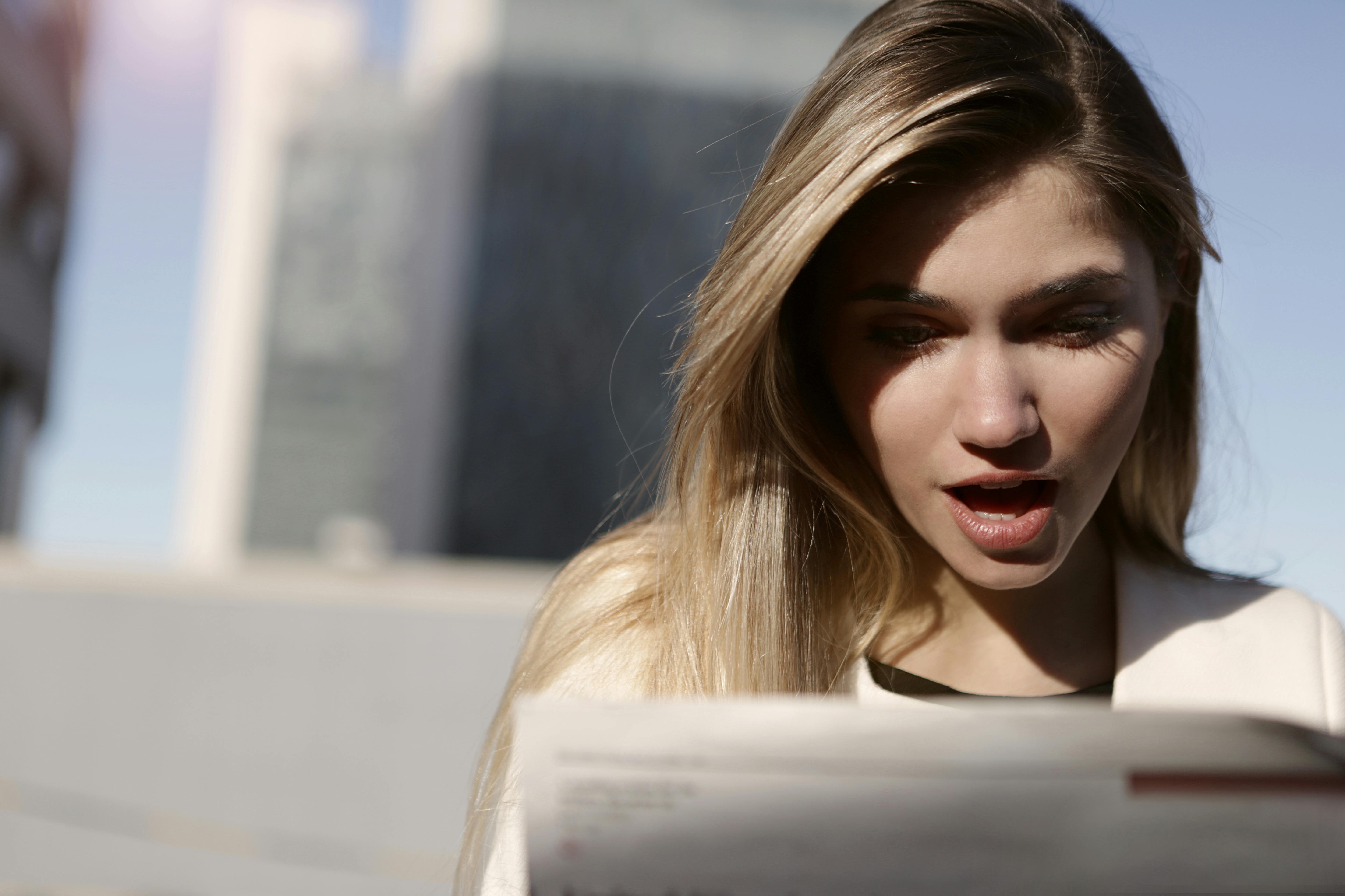 Una mujer sorprendida leyendo algo | Fuente: Pexels