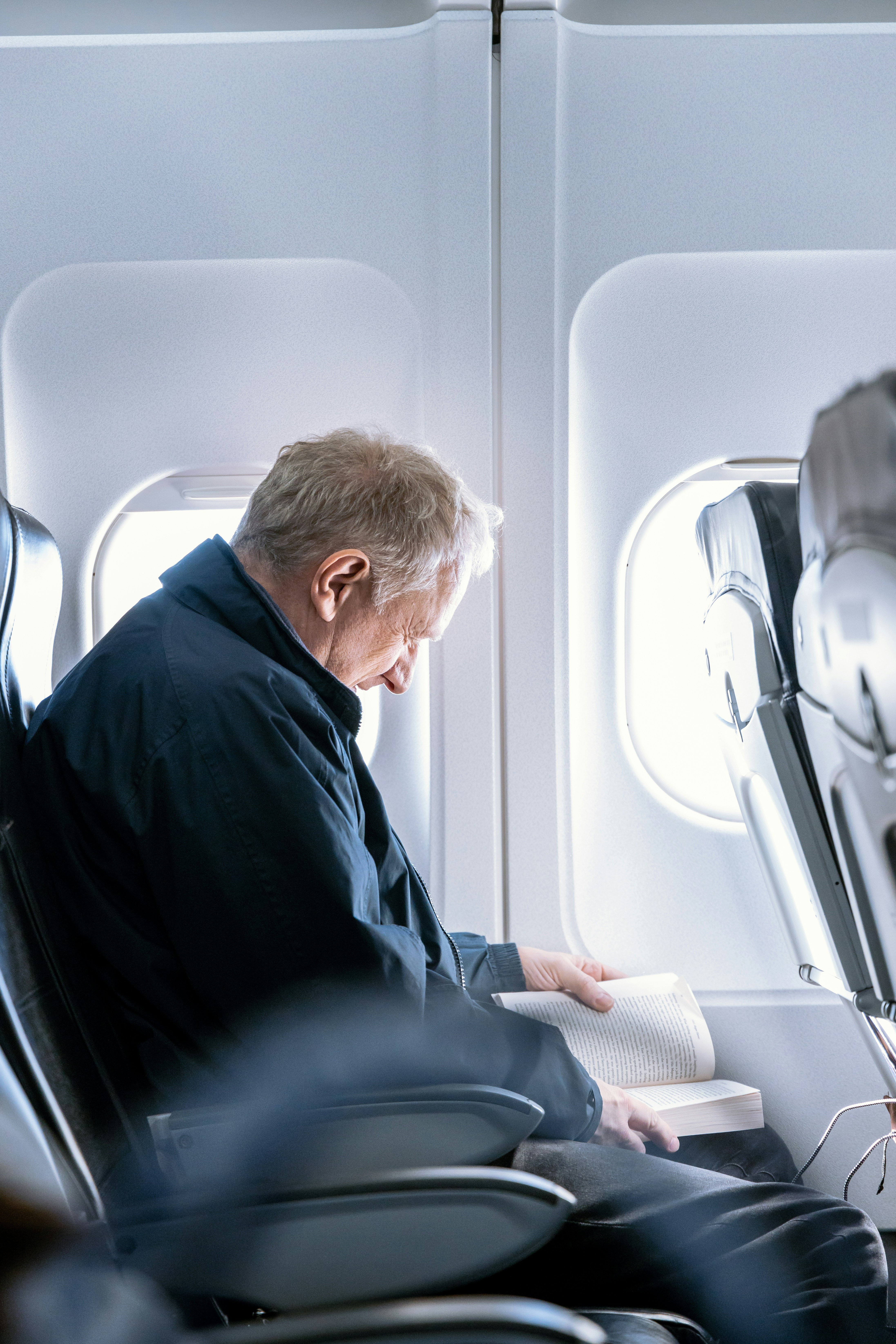 Hombre leyendo un libro dentro de un avión | Fuente: Unsplash