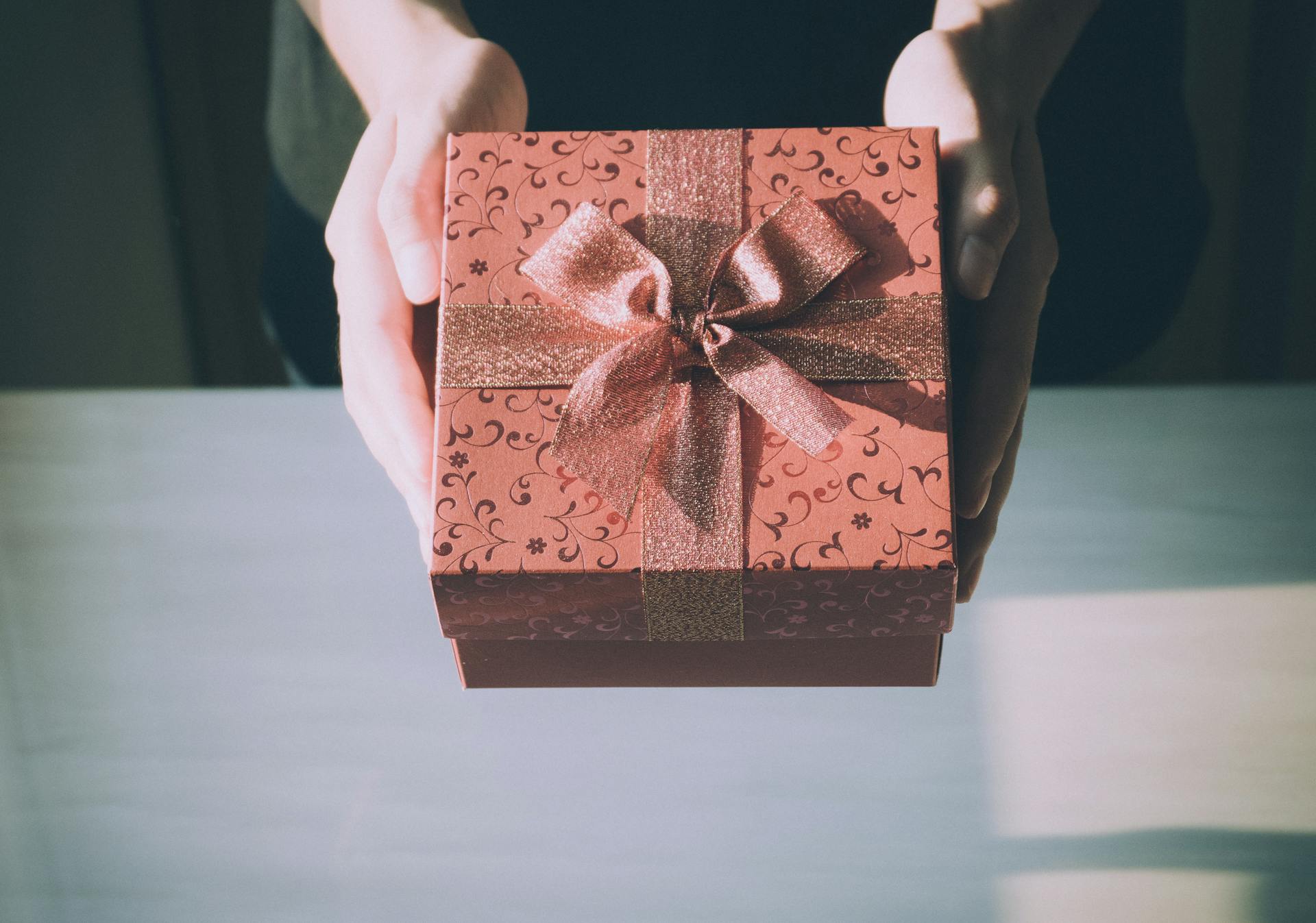 Una persona tendiendo un regalo | Fuente: Pexels