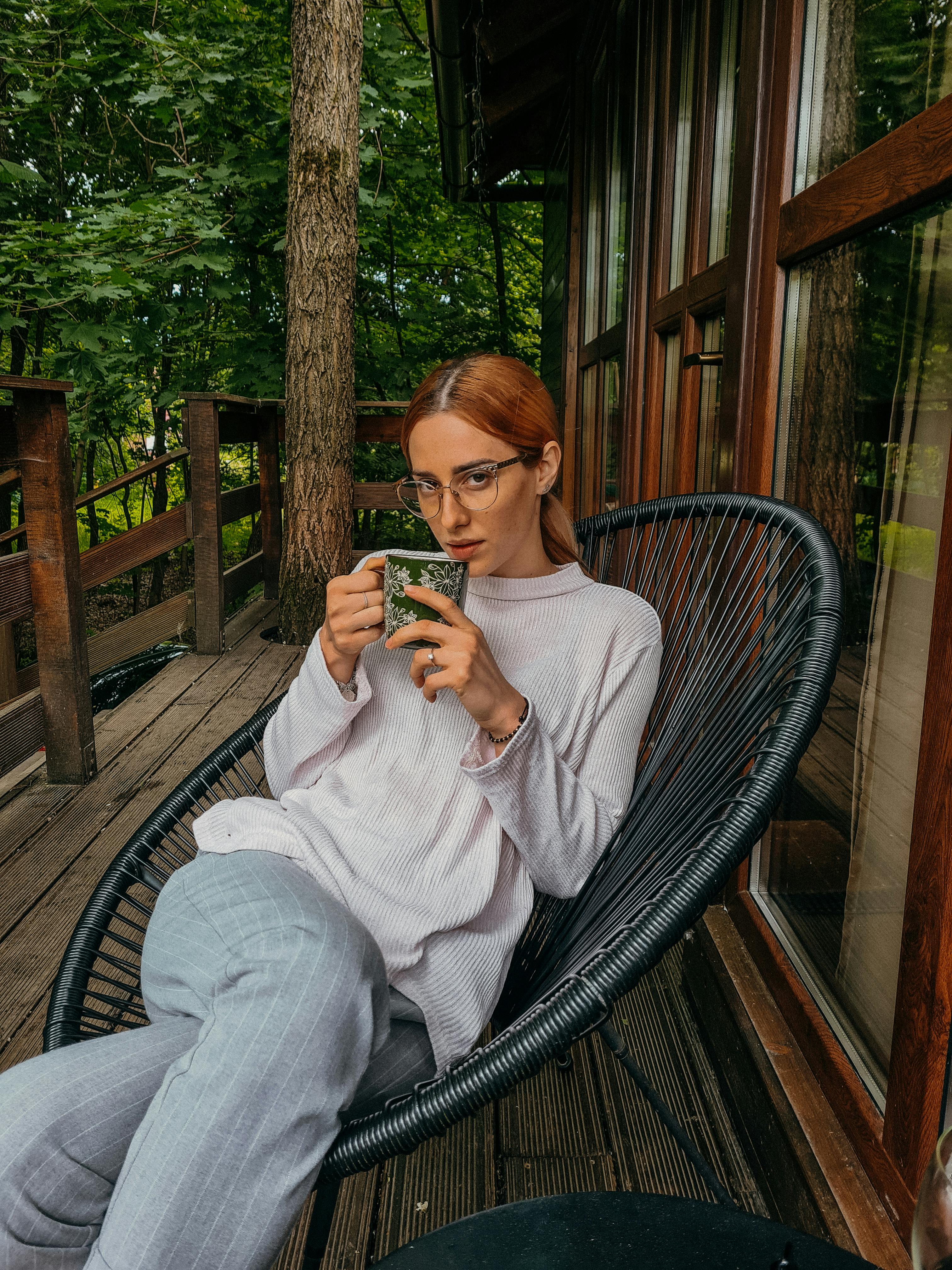 Una mujer sentada en su porche con té | Fuente: Pexels