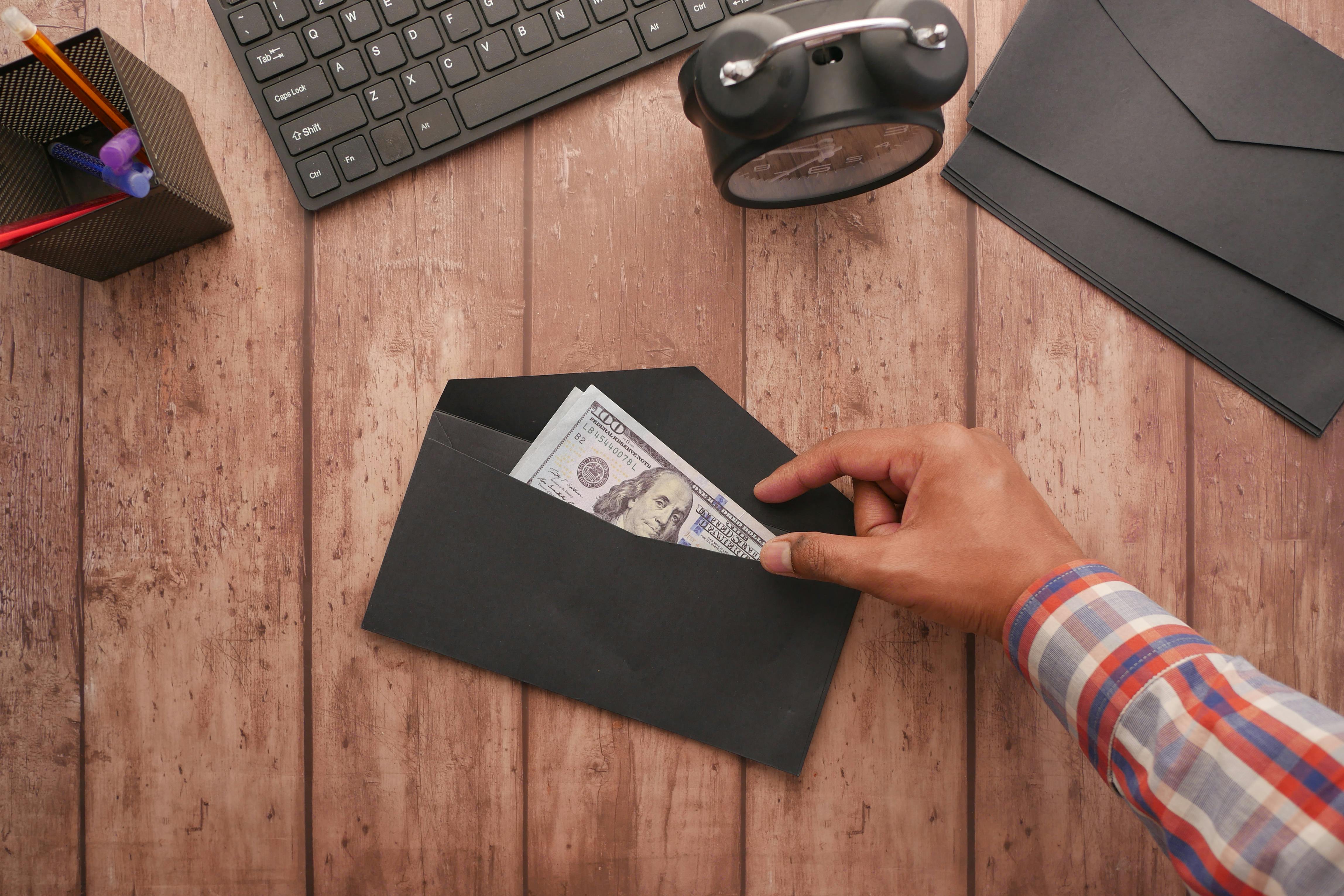 Hombre comprobando el dinero del sobre | Fuente: Pexels