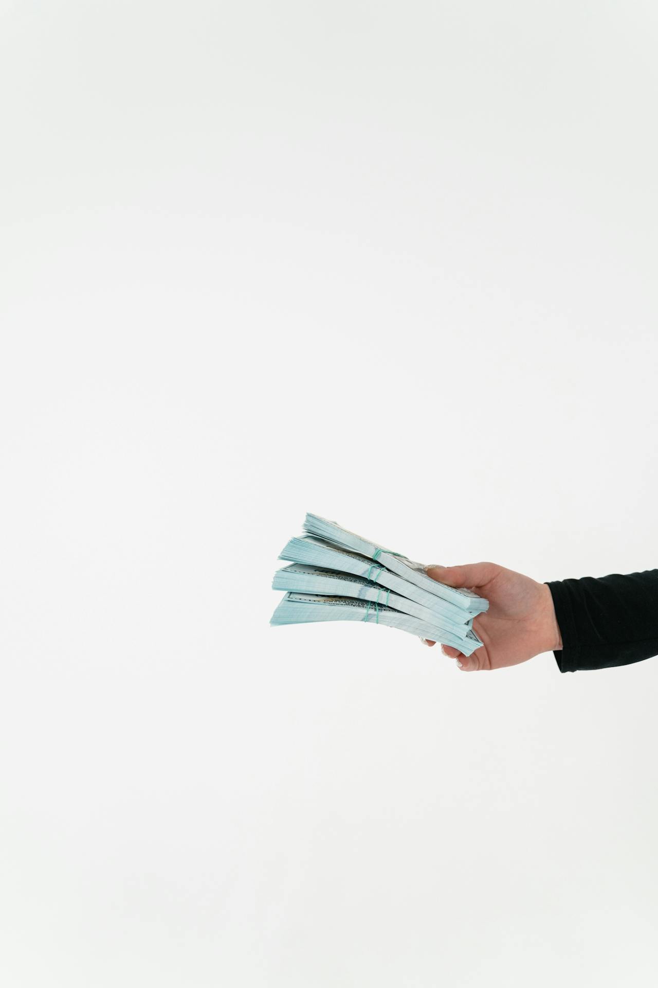 Una mujer sosteniendo fajos de dinero | Fuente: Pexels