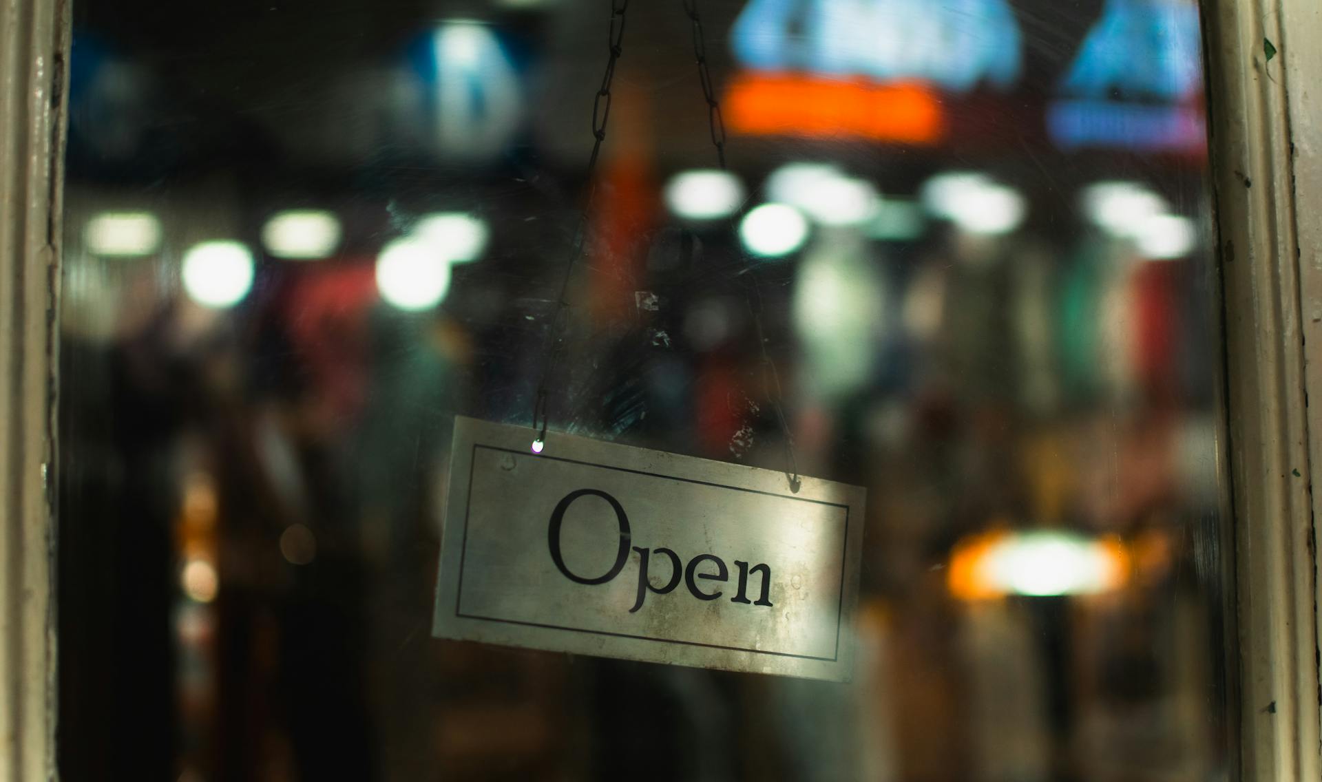 Un cartel de abierto en una puerta | Fuente: Pexels
