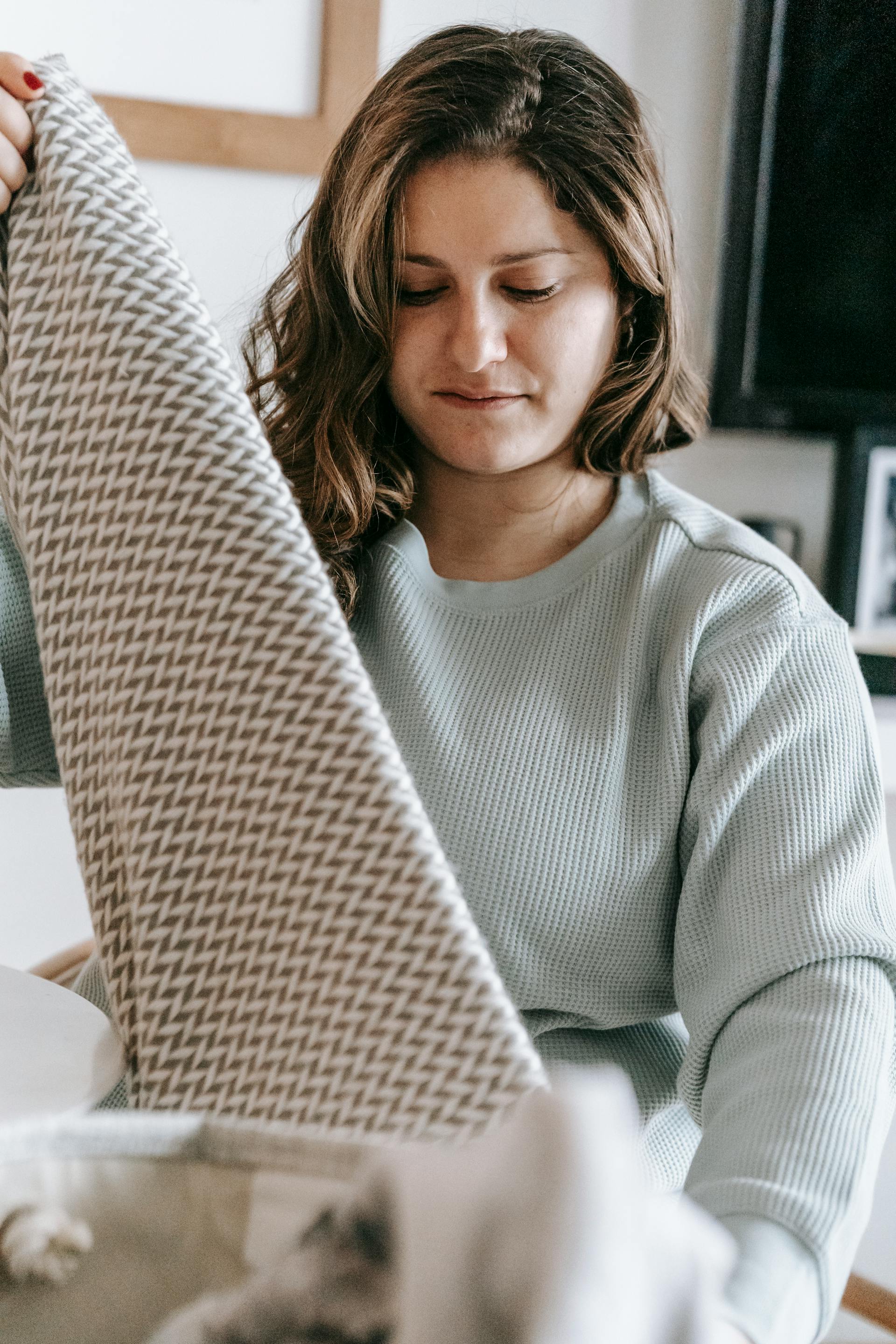 Una mujer doblando la ropa | Fuente: Pexels