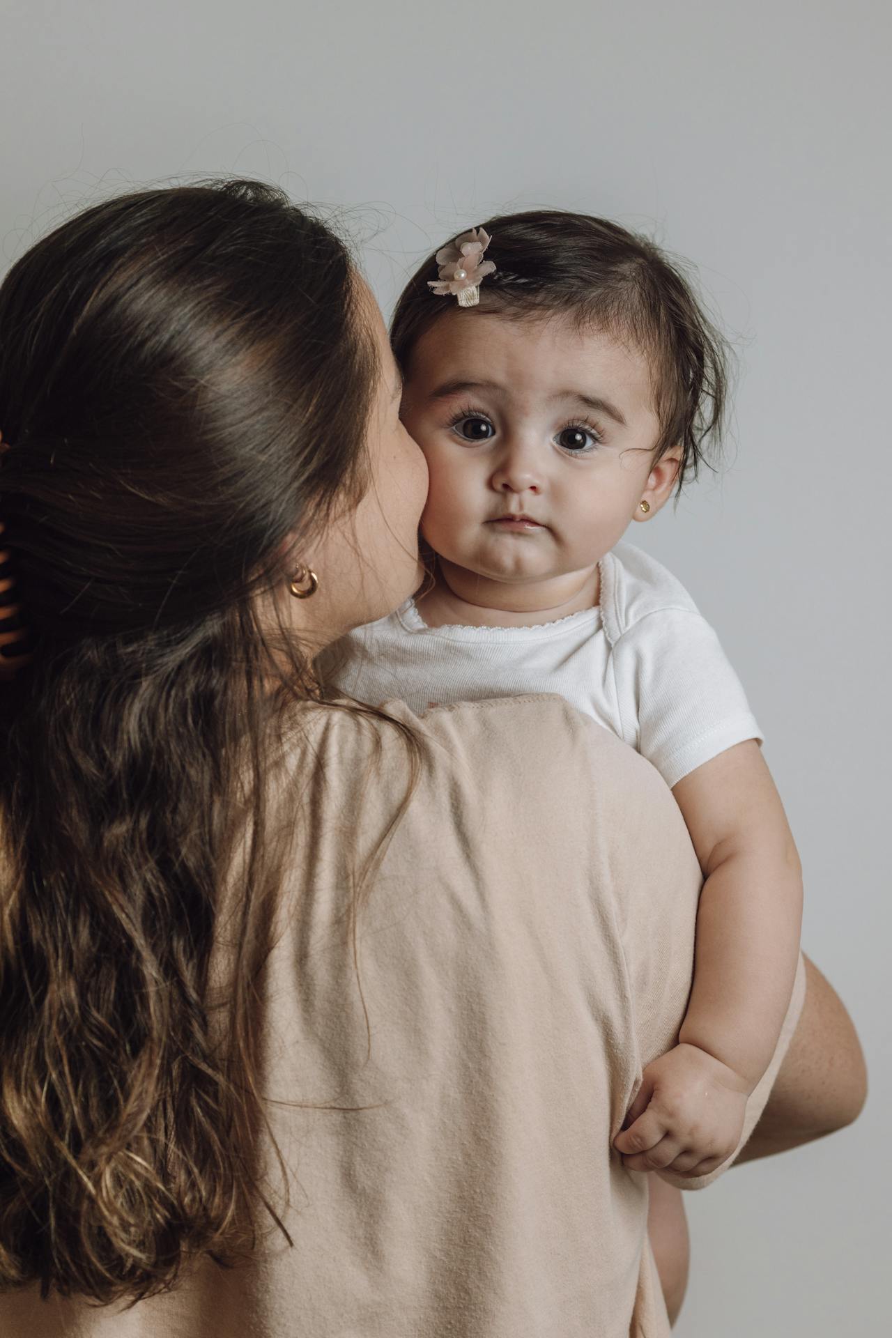 Una madre encantada llevando en brazos a una adorable niña | Fuente: Pexels