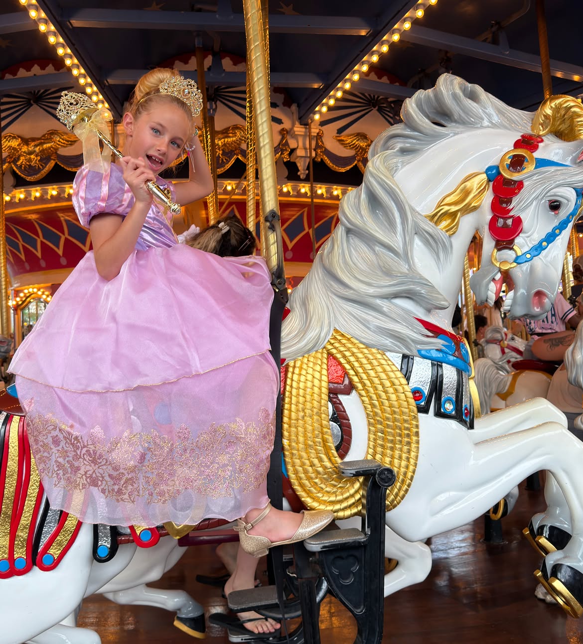 Matilda Salazar posando con su vestido rosa de princesa sobre un caballo de carrusel en Magic Kingdom | Fuente: Instagram/lovingmatilda