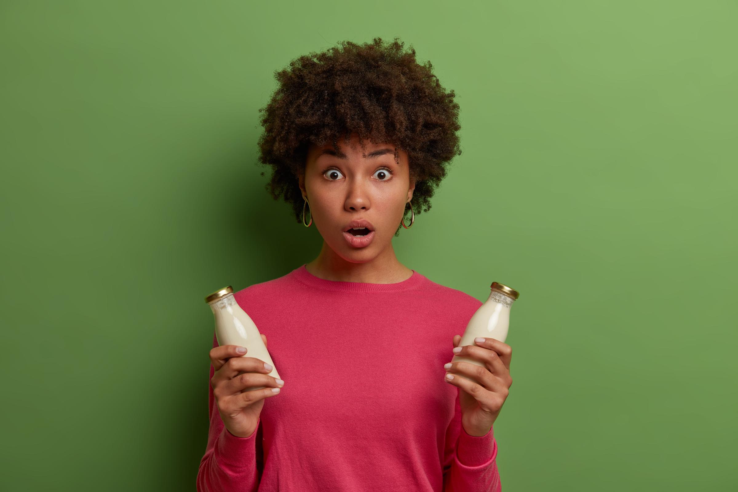 Una mujer conmocionada sosteniendo leche | Fuente: Freepik