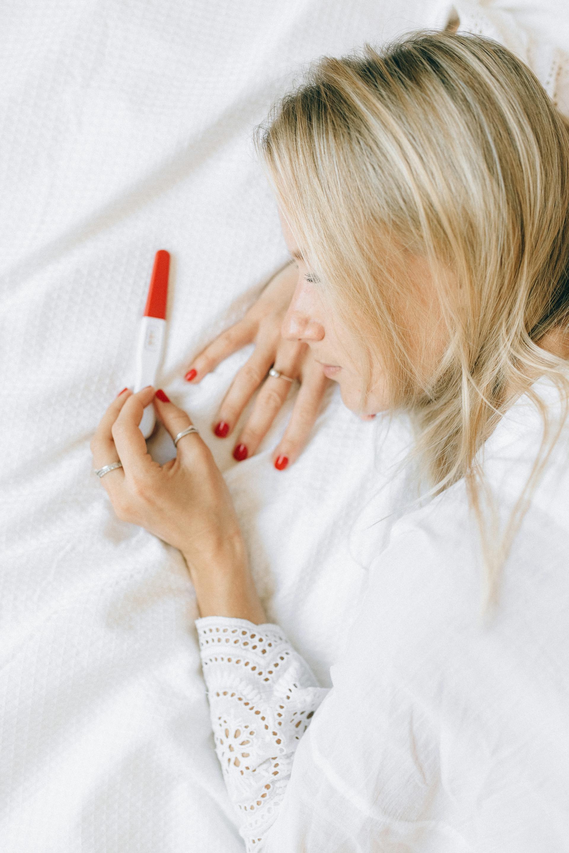 Una mujer mirando tristemente un test de embarazo | Fuente: Pexels