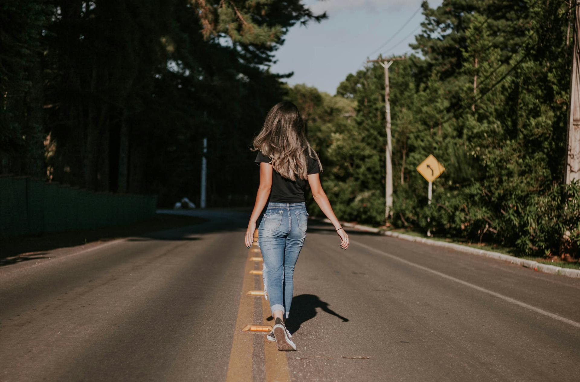 Una mujer caminando por la carretera | Fuente: Pexels