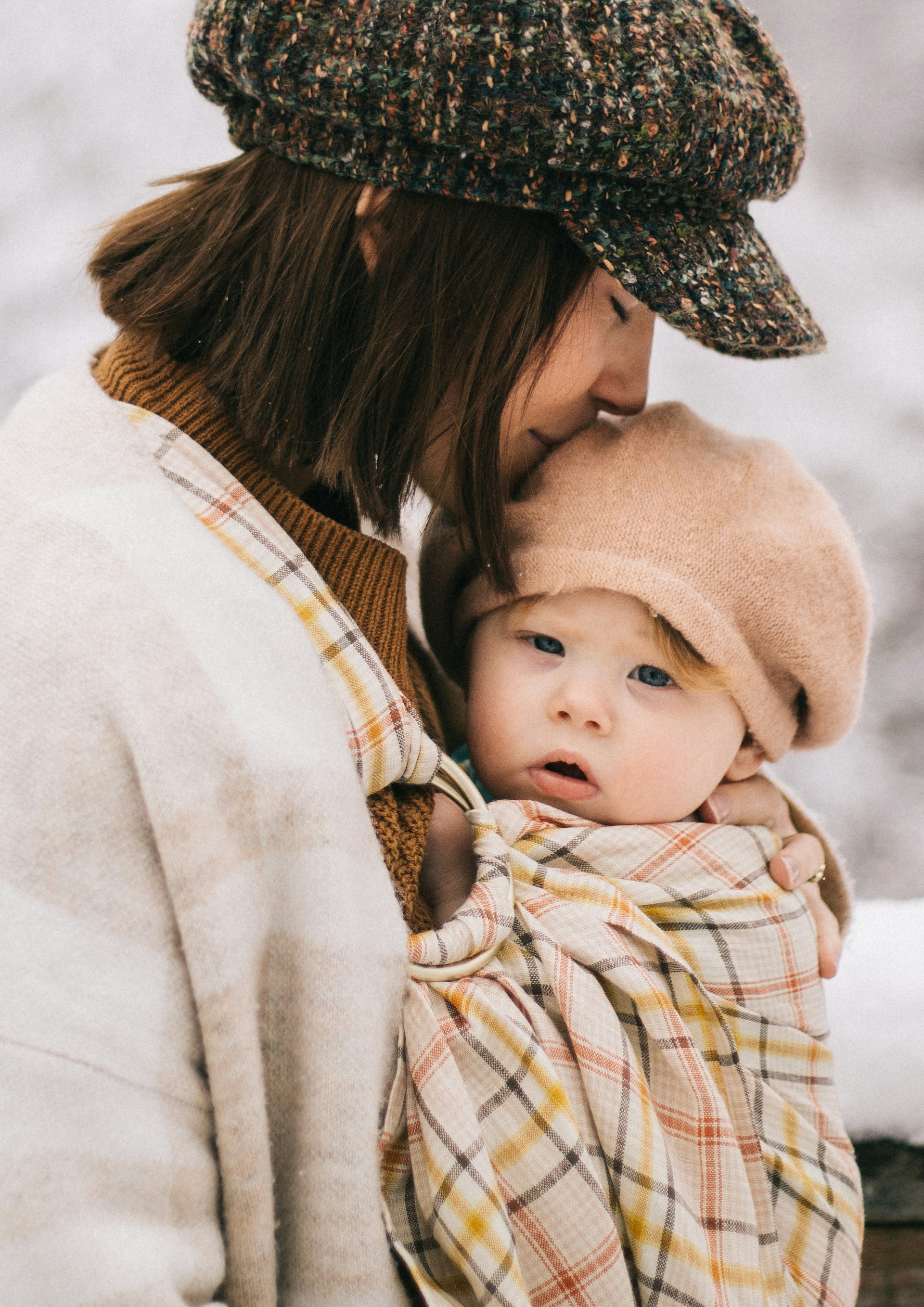 Una mujer besa suavemente a su hijo, representando el amor incondicional de una madre | Fuente: Unsplash