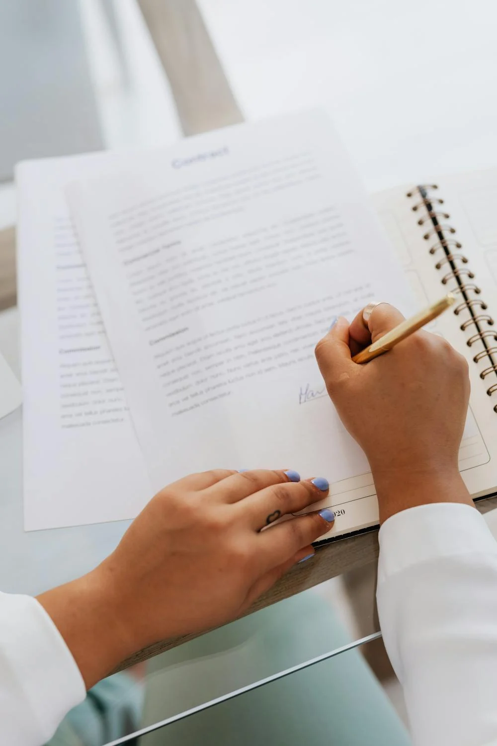 Una mujer firmando papeles | Fuente: Pexels