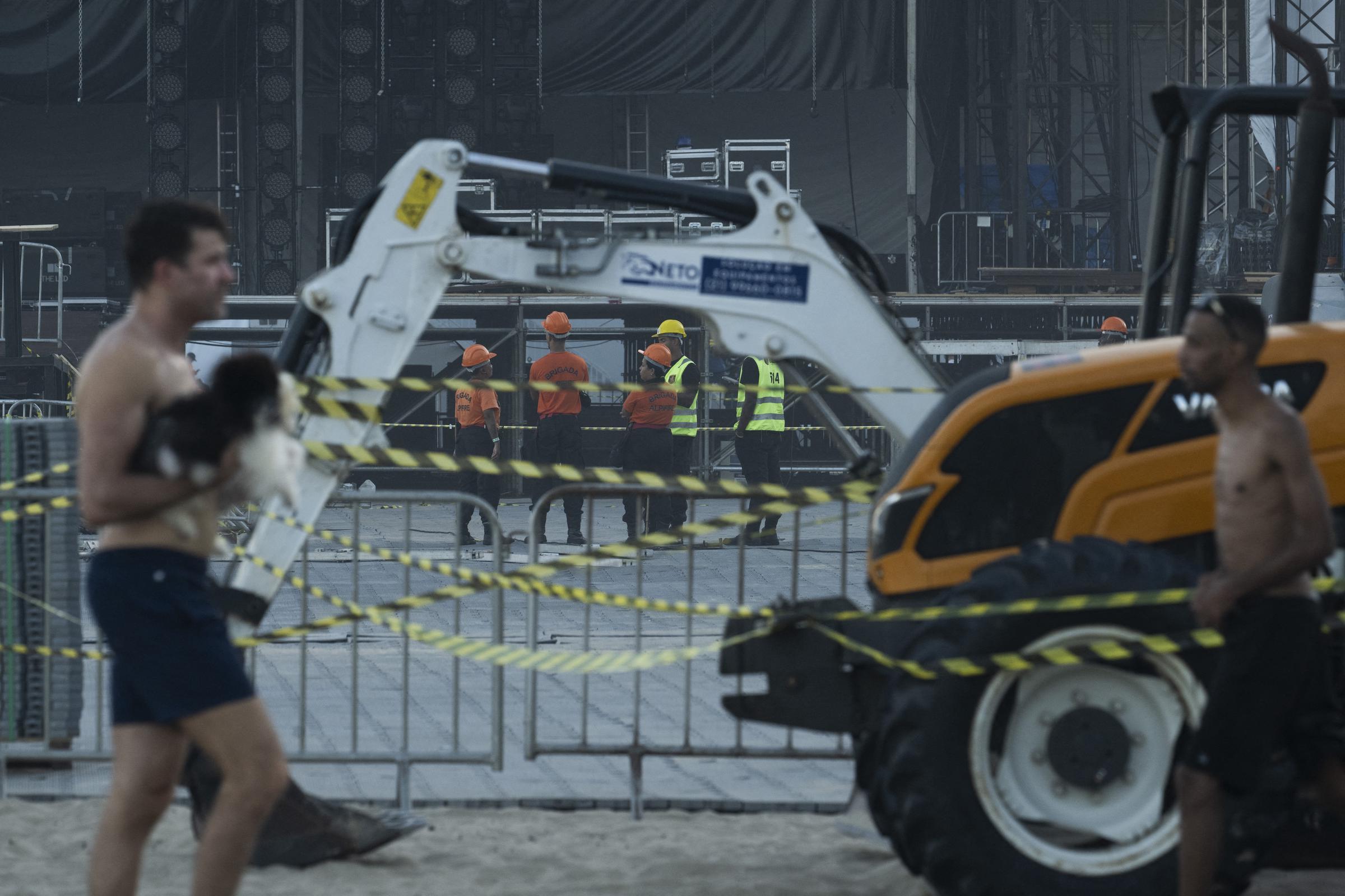 Trabajadores y maquinaria permanecen inactivos tras la muerte de un trabajador en un accidente ocurrido durante el montaje del escenario para la cantante colombiana Shakira en la playa de Copacabana, en Río de Janeiro, Brasil, el 26 de abril de 2026. | Fuente: Getty Images