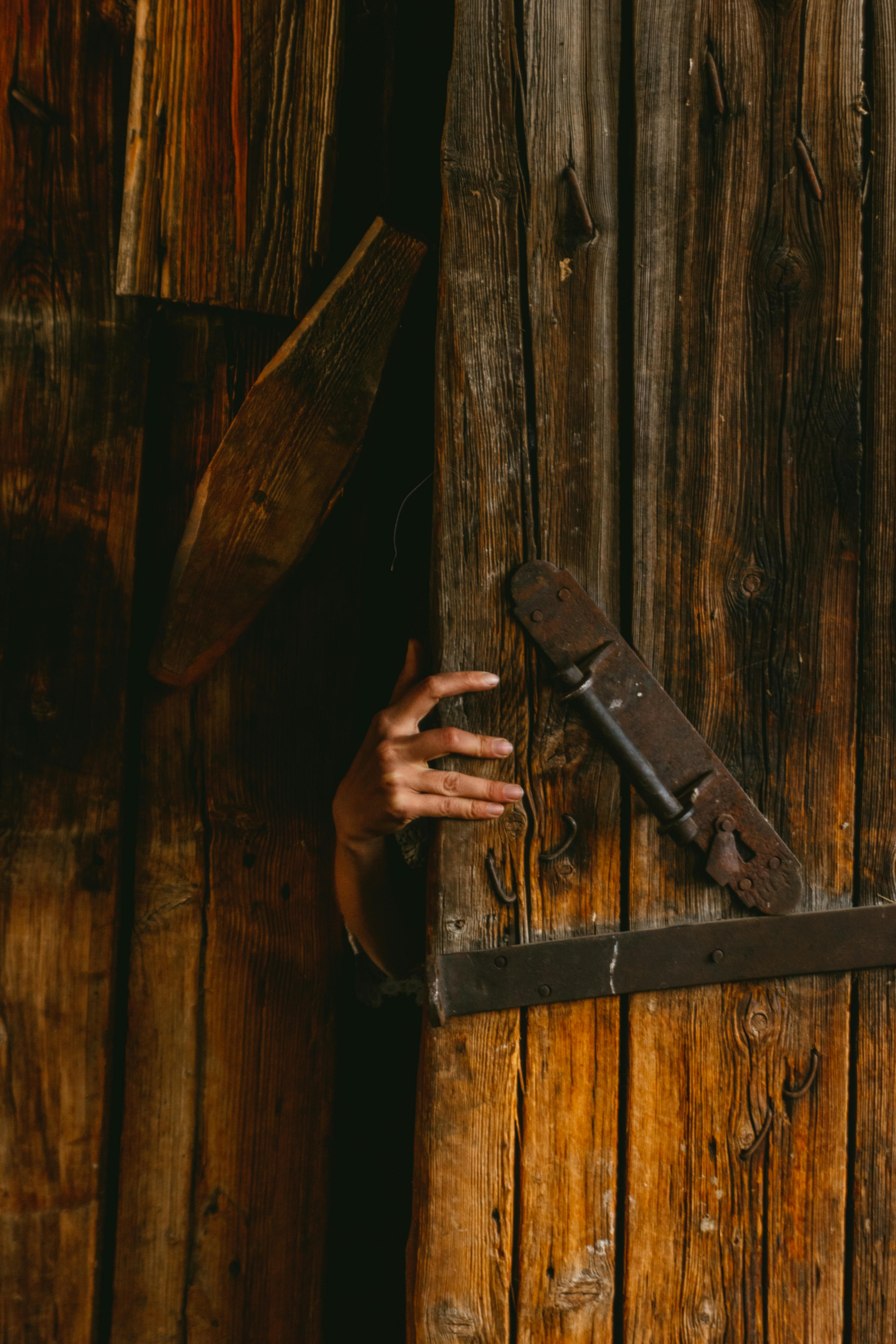 Una mano abriendo la puerta de un cobertizo | Fuente: Pexels