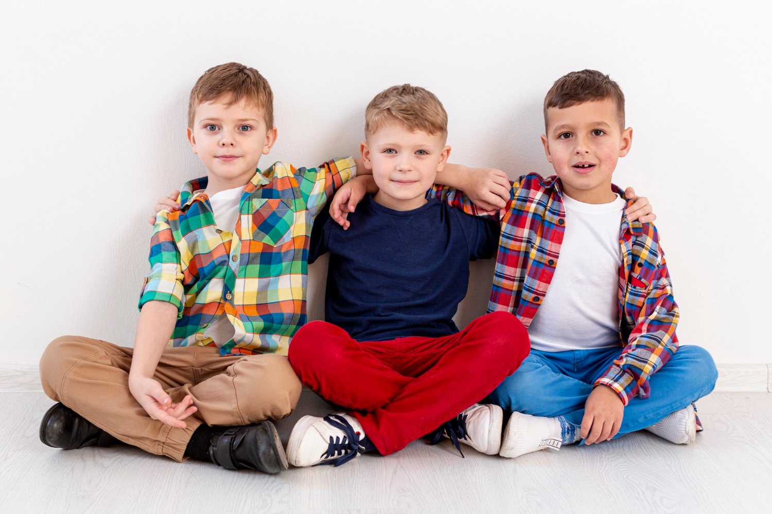 Tres chicos jóvenes sentados juntos | Fuente: Freepik