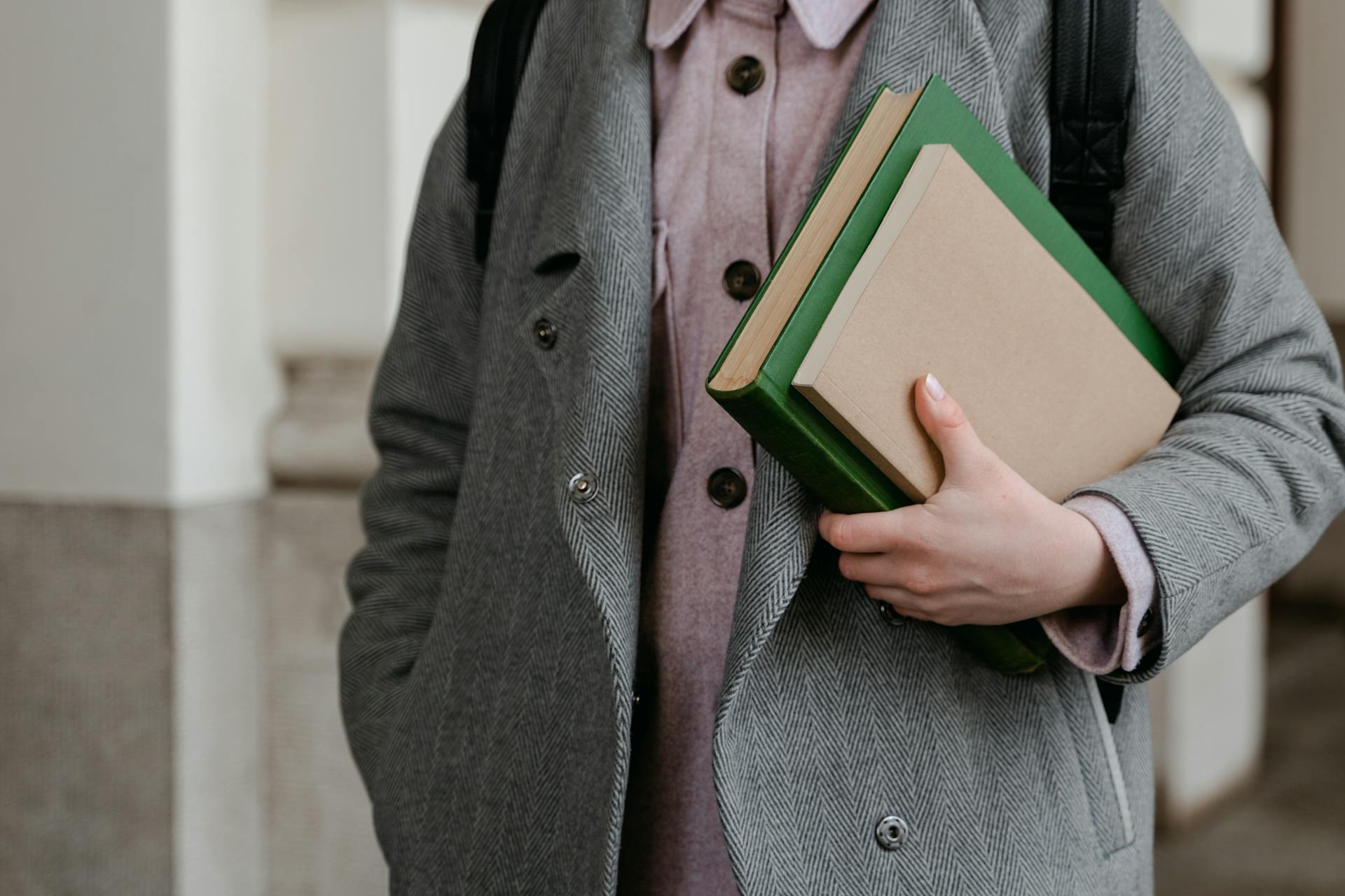 Una persona sujetando un par de libros | Fuente: Pexels