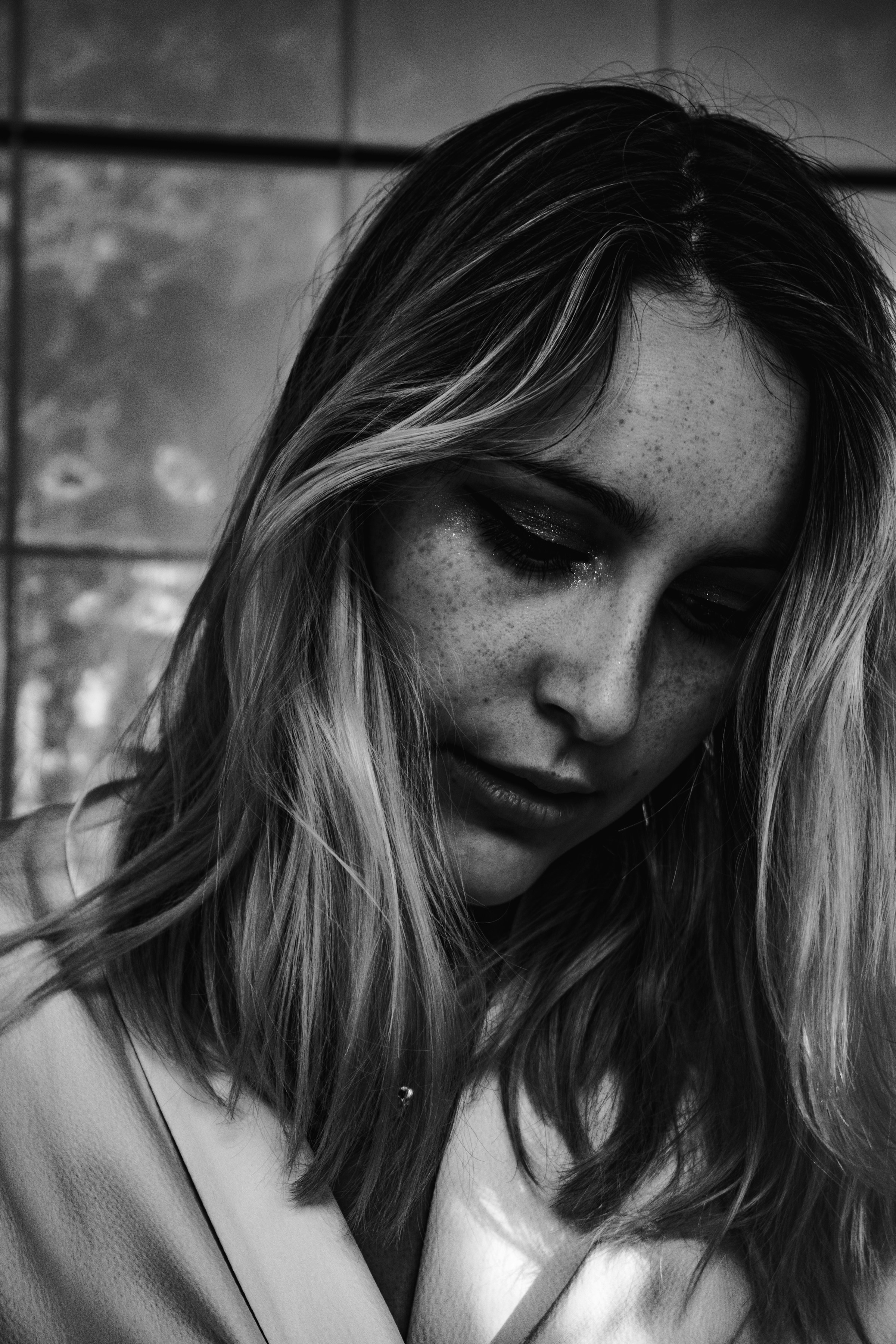 Foto en escala de grises de una mujer angustiada | Fuente: Unsplash