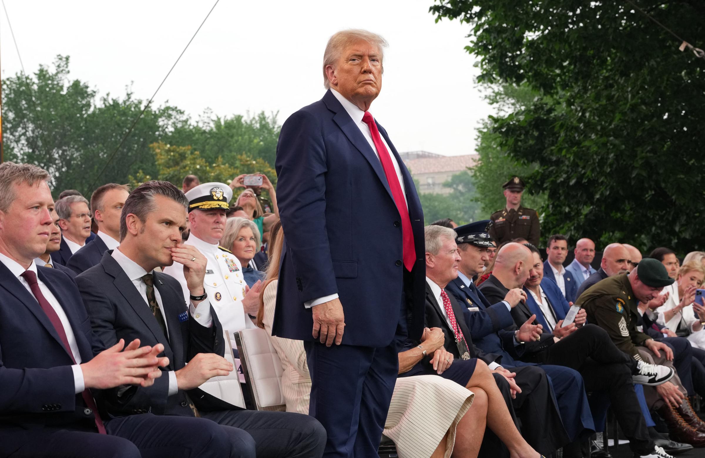 Donald Trump junto con otros se reúnen en el escenario para ver el desfile del 250° aniversario del Ejército de EEUU el 14 de junio de 2025 | Fuente: Getty Images