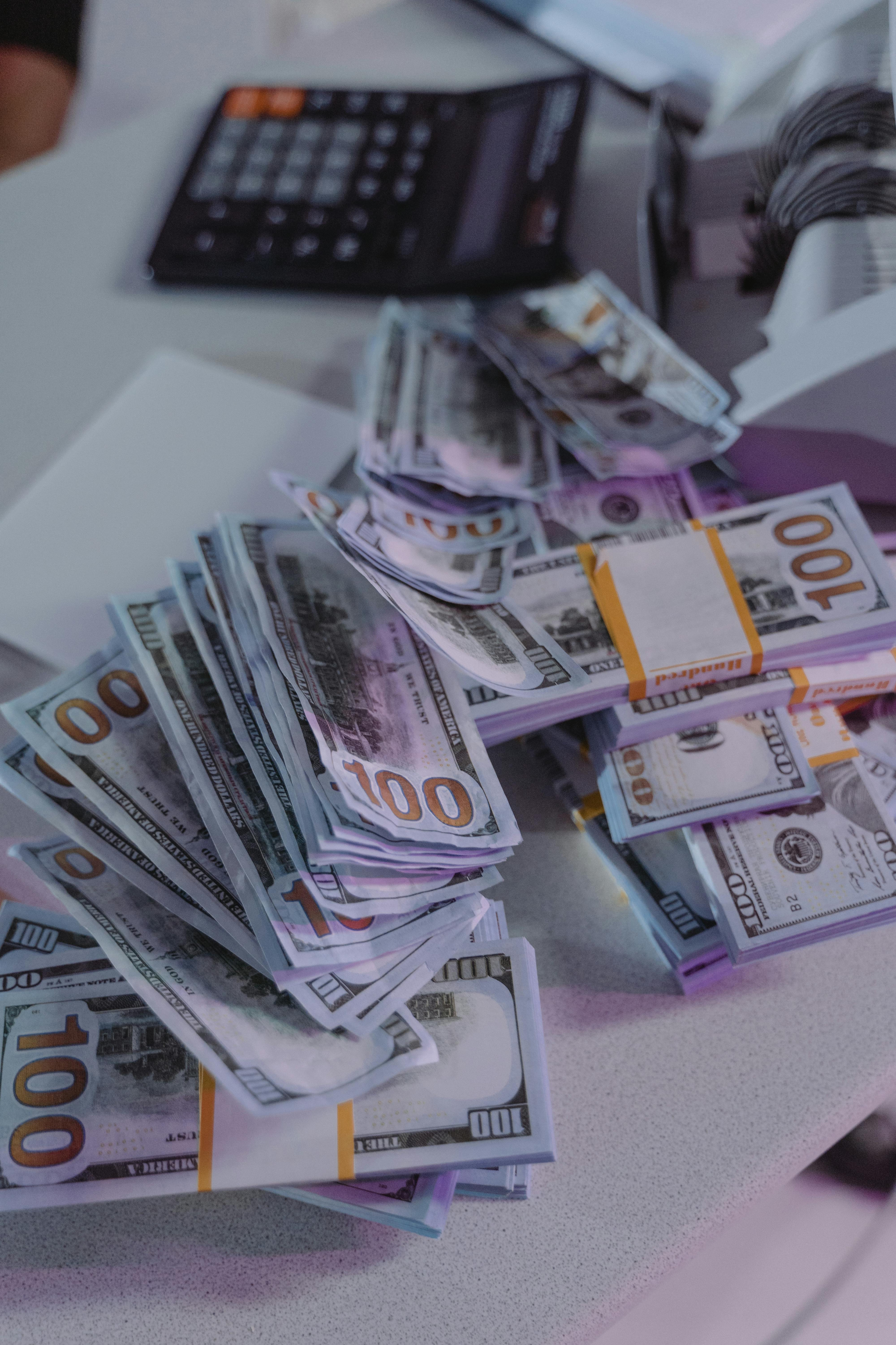Montones de dinero sobre un mostrador | Fuente: Pexels