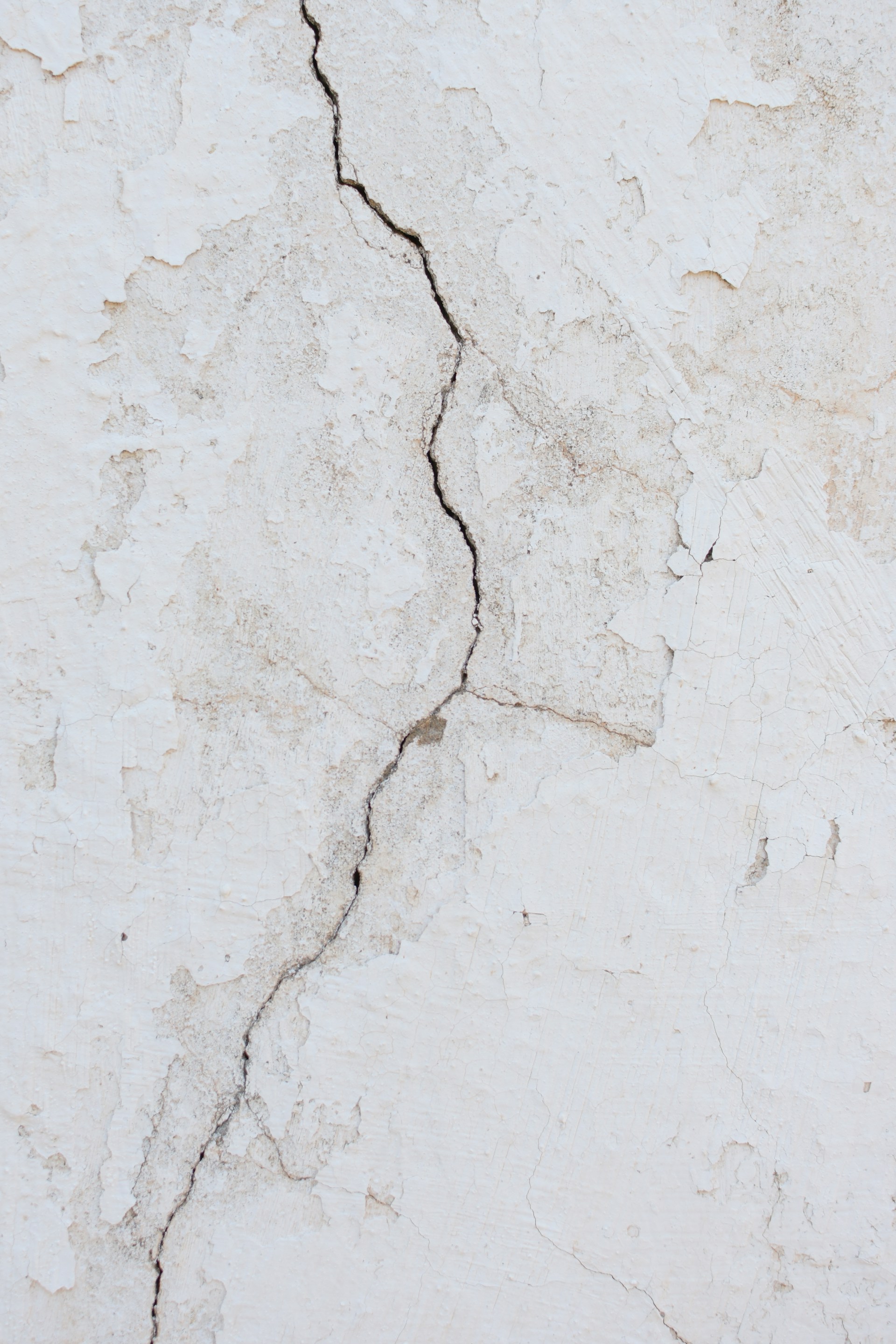 Grietas en una vieja pared blanca | Fuente: Unsplash