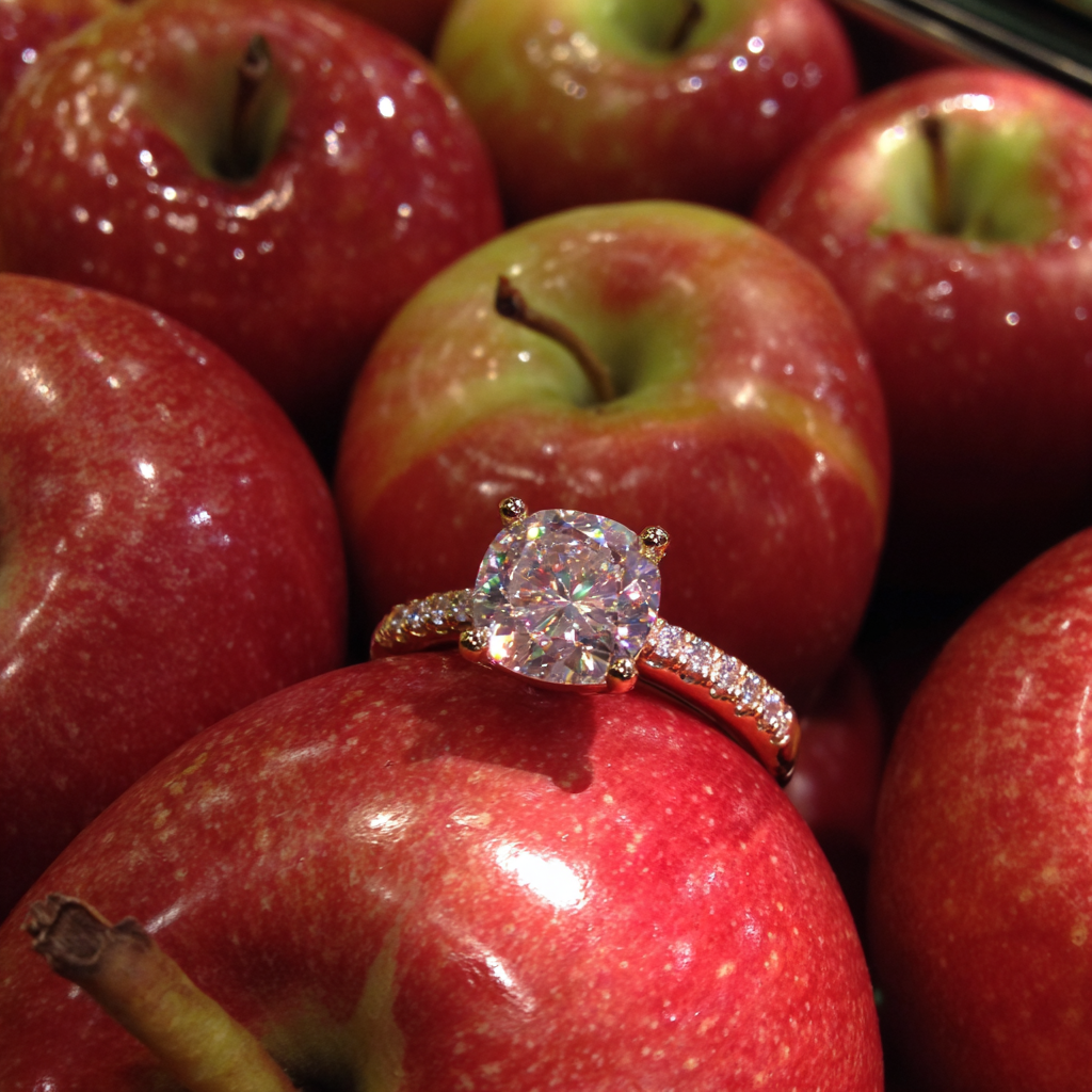 Un anillo de diamantes en un expositor con forma de manzana en la tienda | Fuente: Midjourney